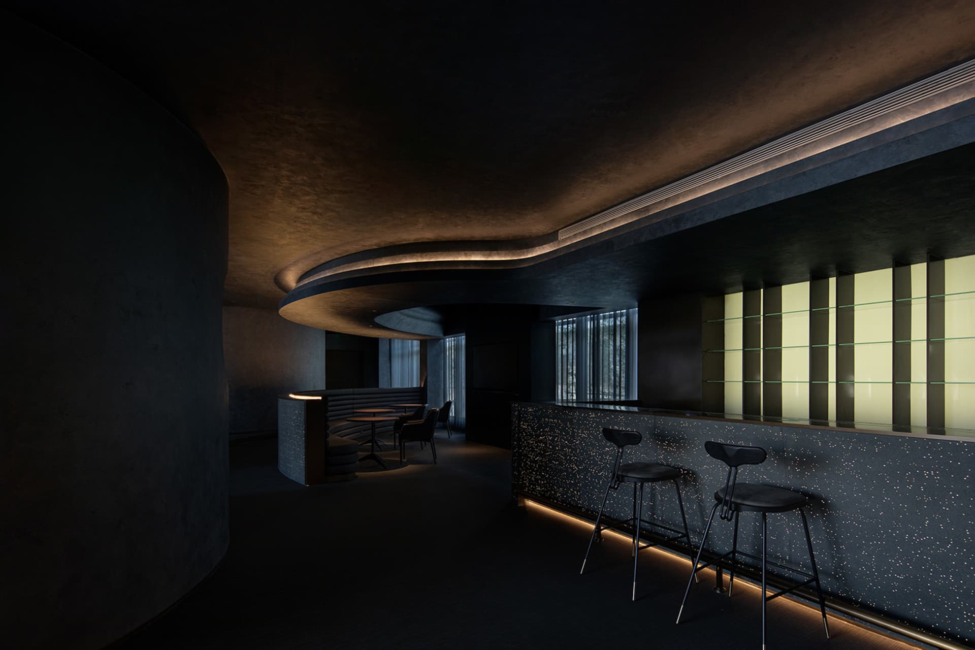 Modern bar with concrete walls, glass windows, and metallic accents