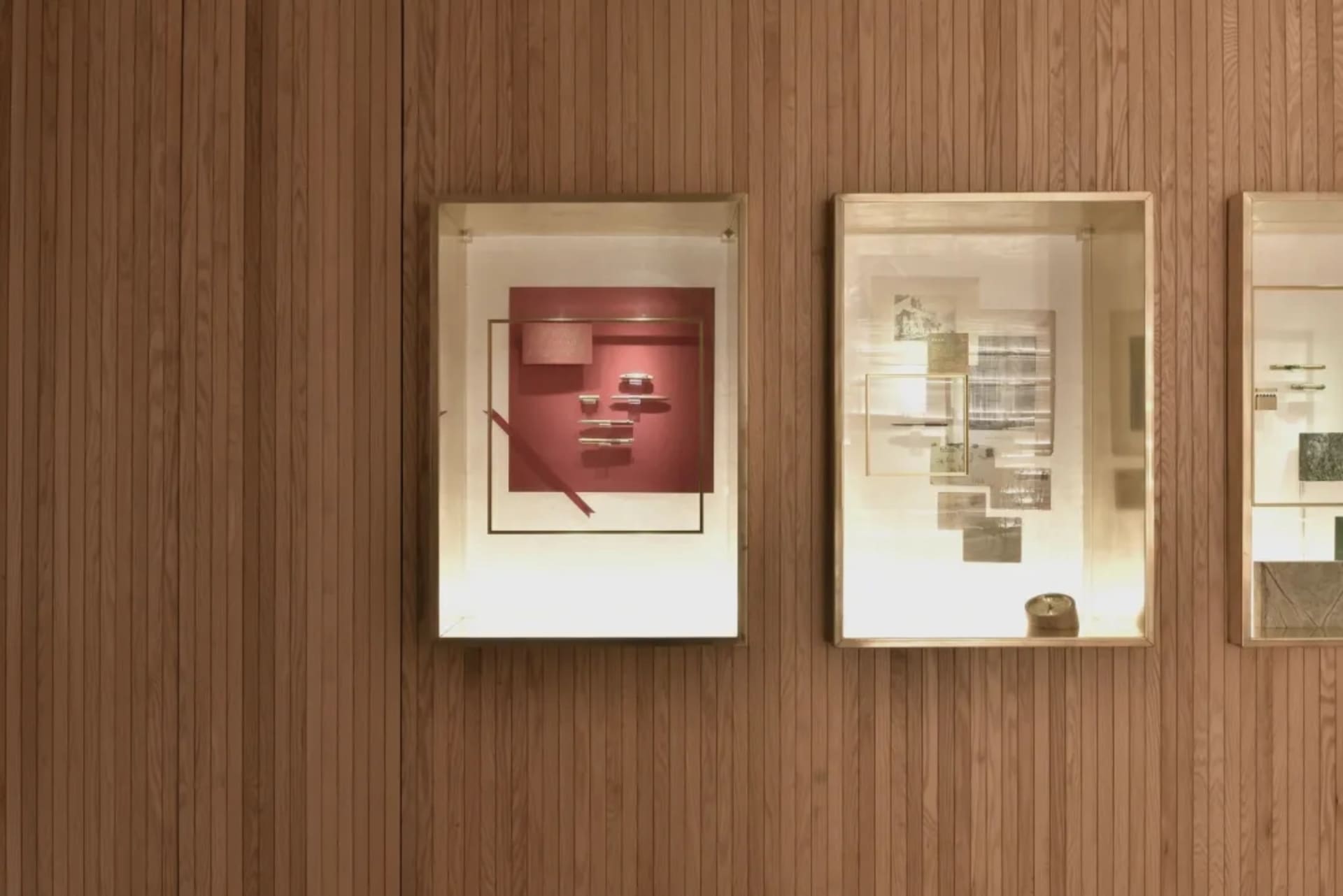 Glass-enclosed exhibit cases displaying various art pieces.