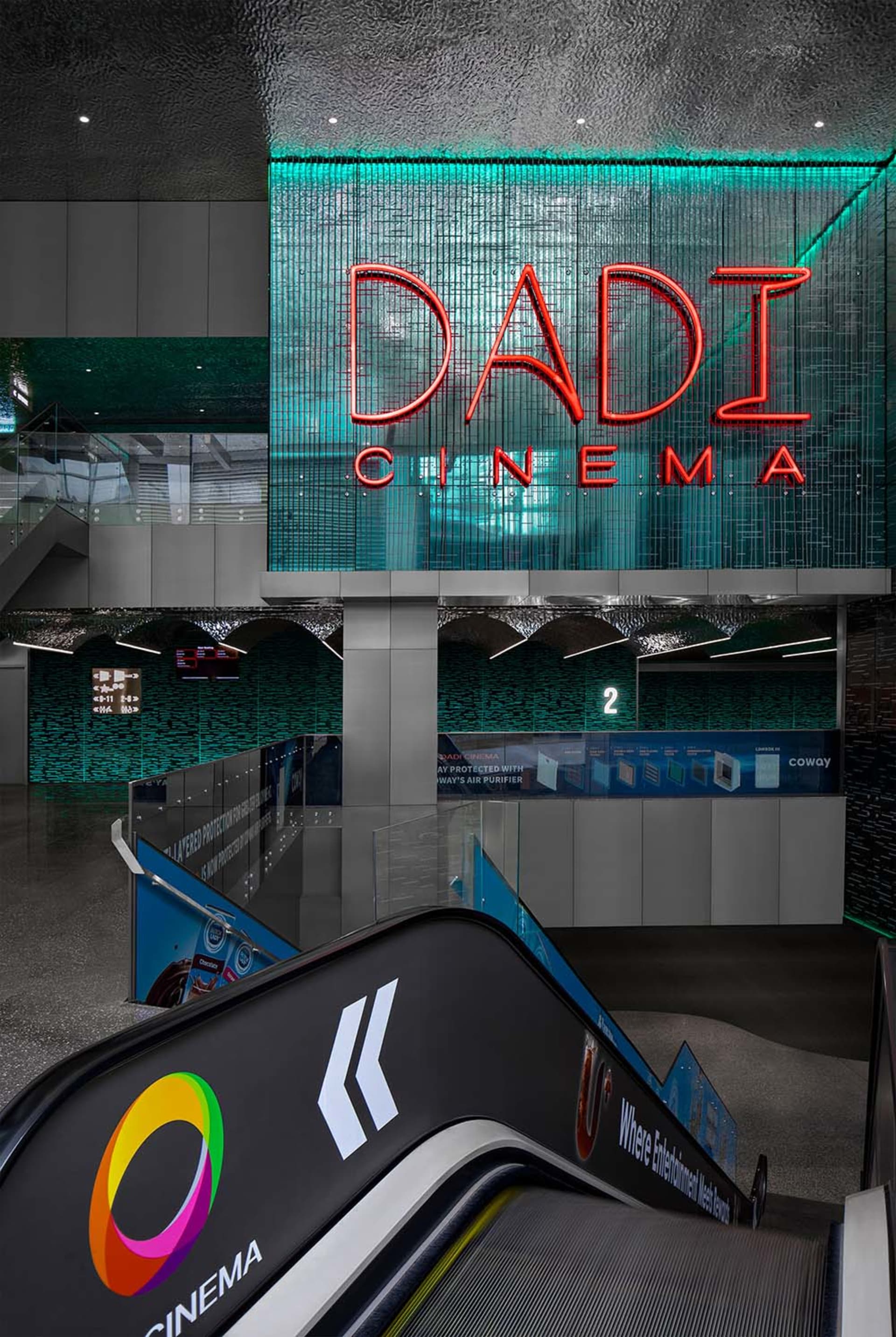 A modern cinema lobby featuring metal, glass, and concrete materials.