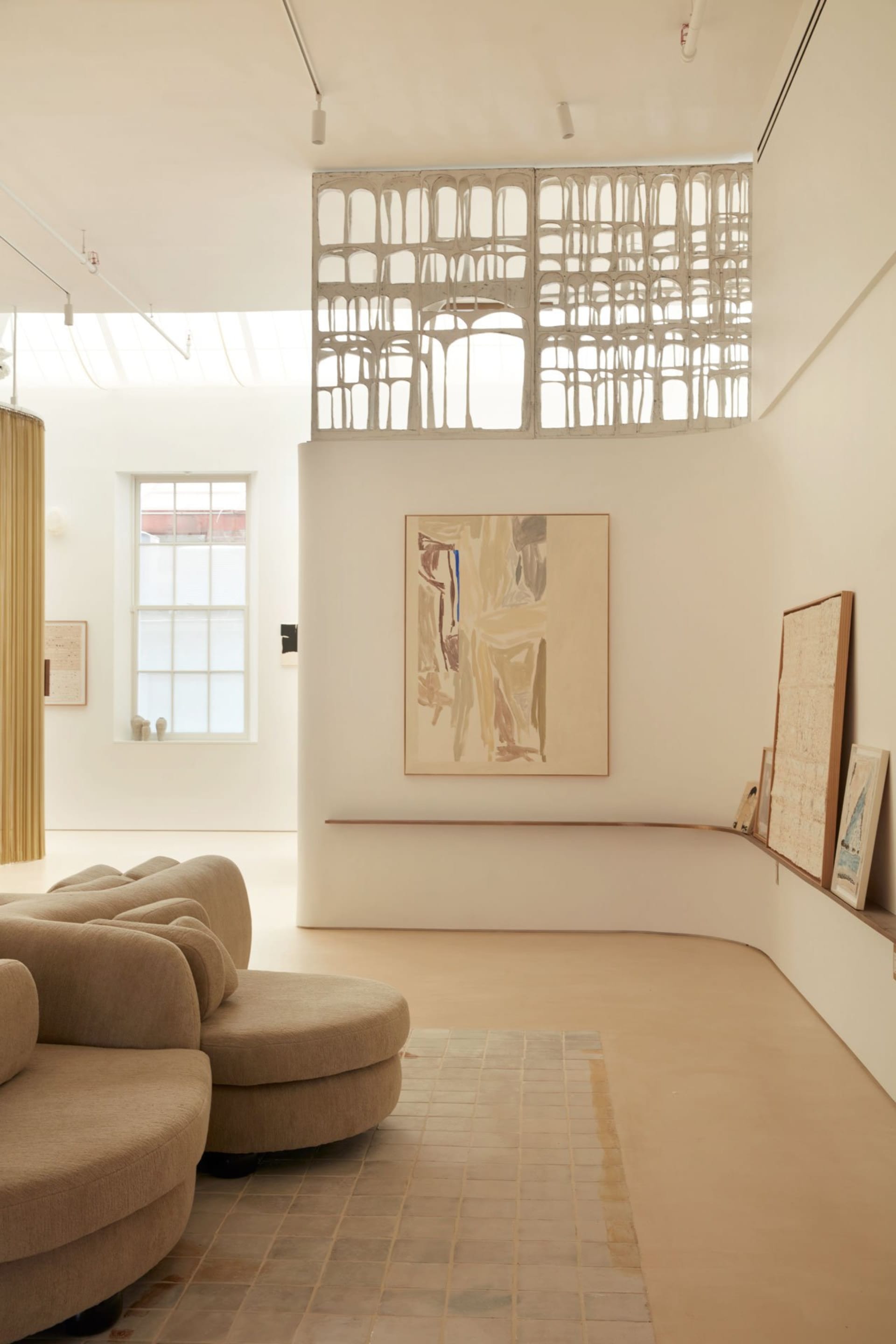 Modern living room with neutral-colored furniture and minimalist artwork.