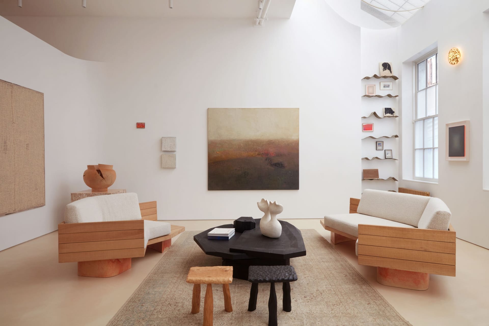 A modern living room featuring wooden furniture, a fabric sofa, and a textured rug.