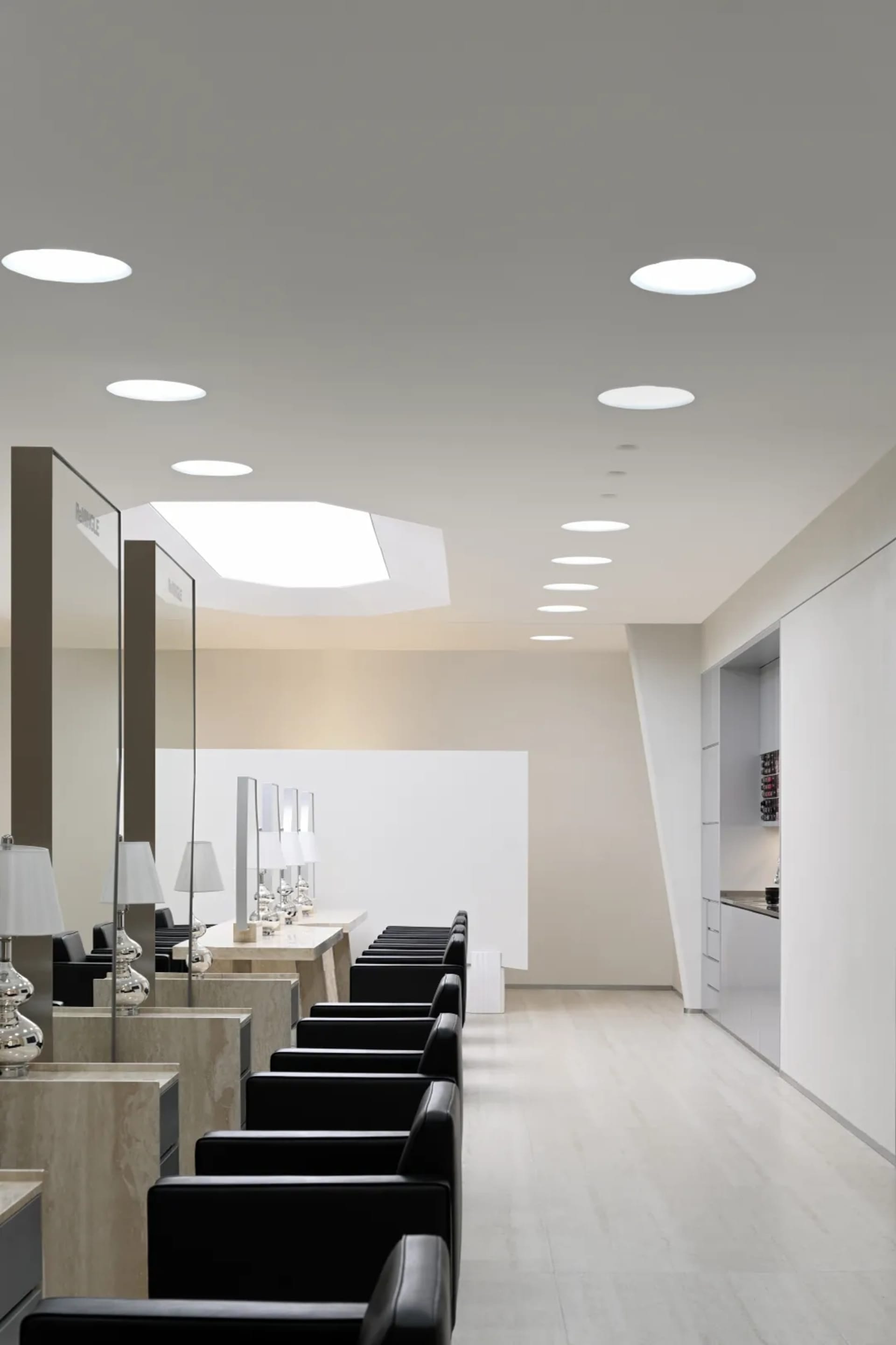 A minimalist waiting room with black seating and marble accents.