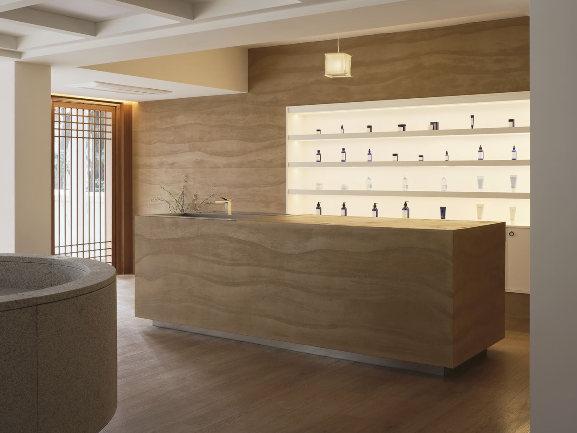 Modern minimalist spa center with a wooden reception desk, metal shelves, and illuminated display case showcasing various wel