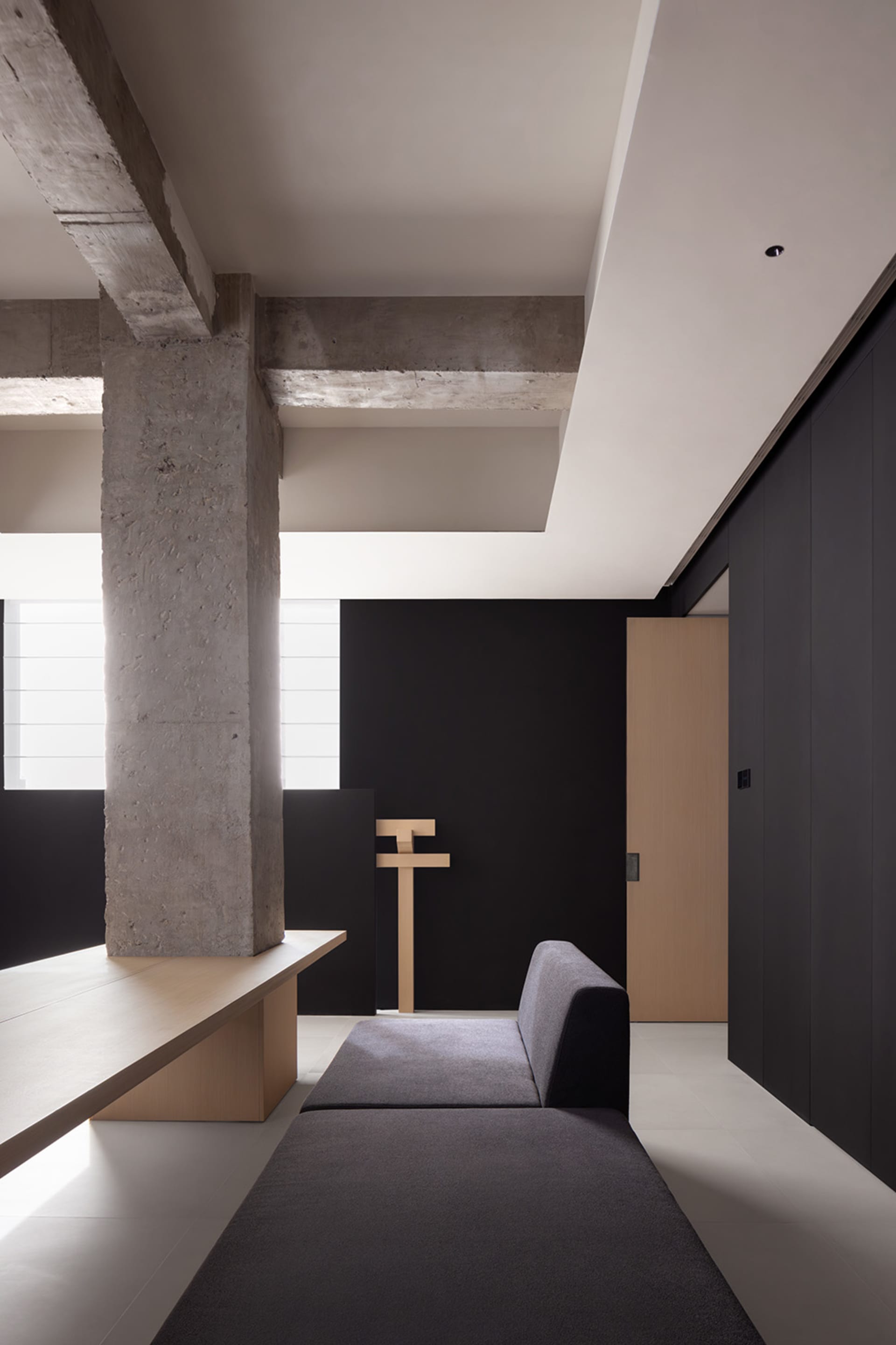 A minimalist residential interior featuring concrete and wood materials.