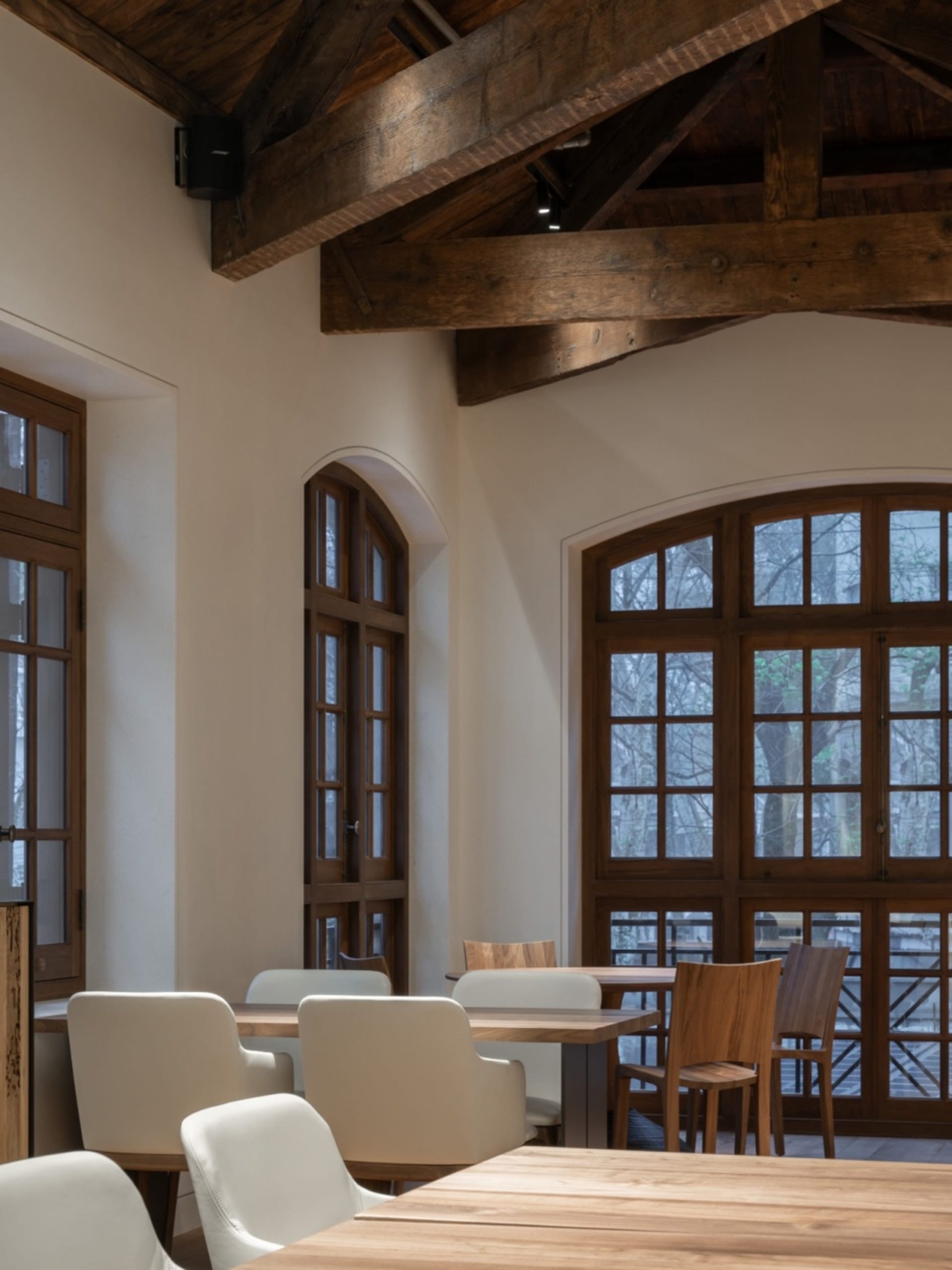Interior of a restaurant featuring reclaimed wood and white furniture.