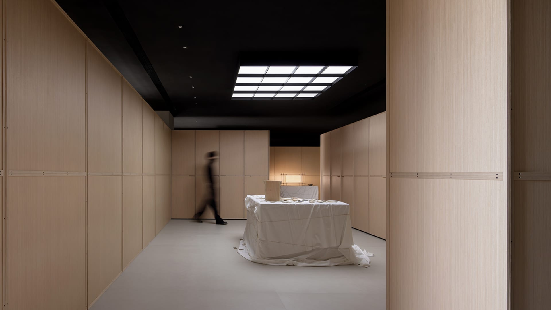 A minimalist office space features light-colored wood walls and furniture, creating a modern and spacious atmosphere.