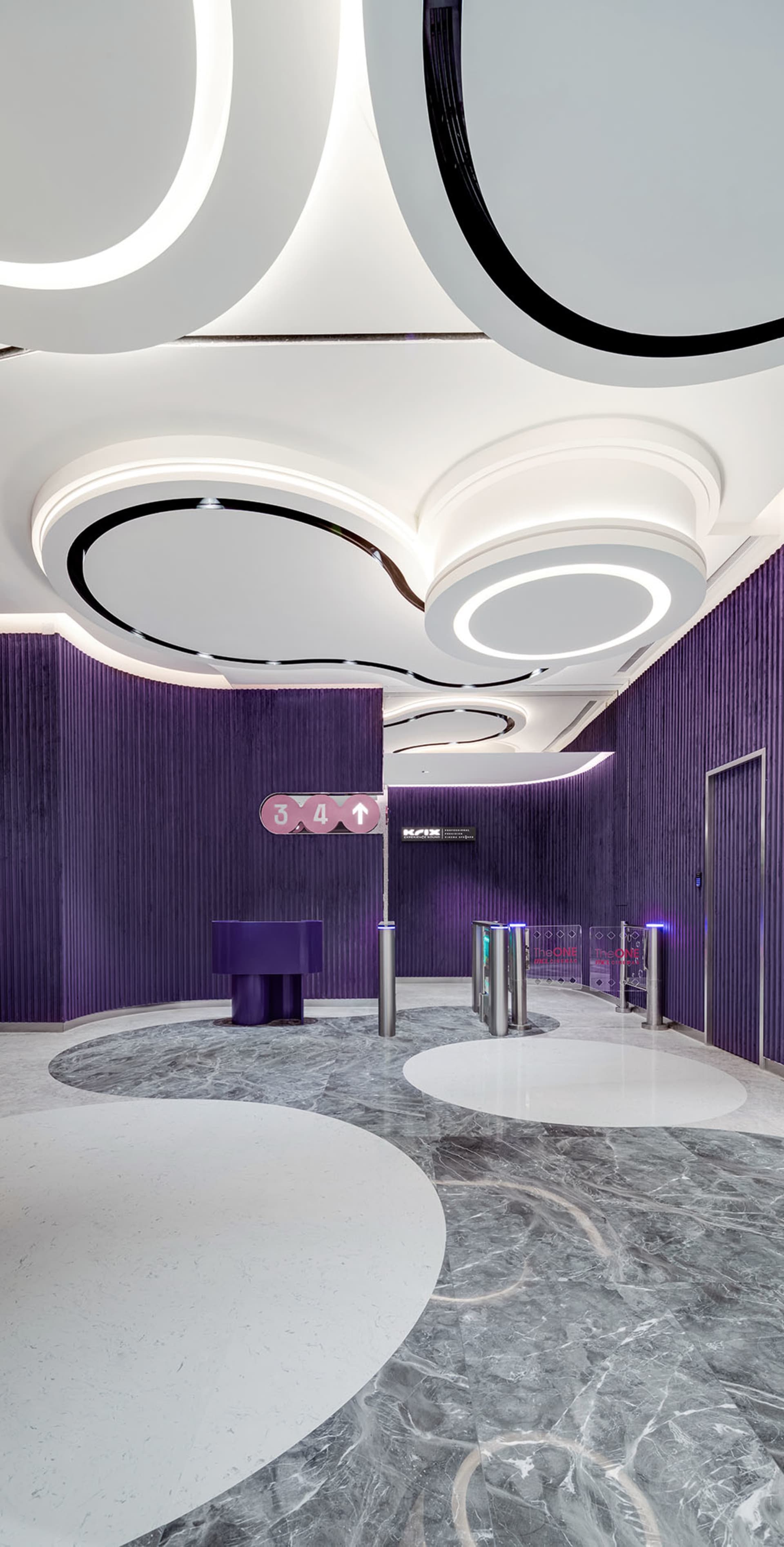 A modern lobby featuring marble flooring and concrete walls.