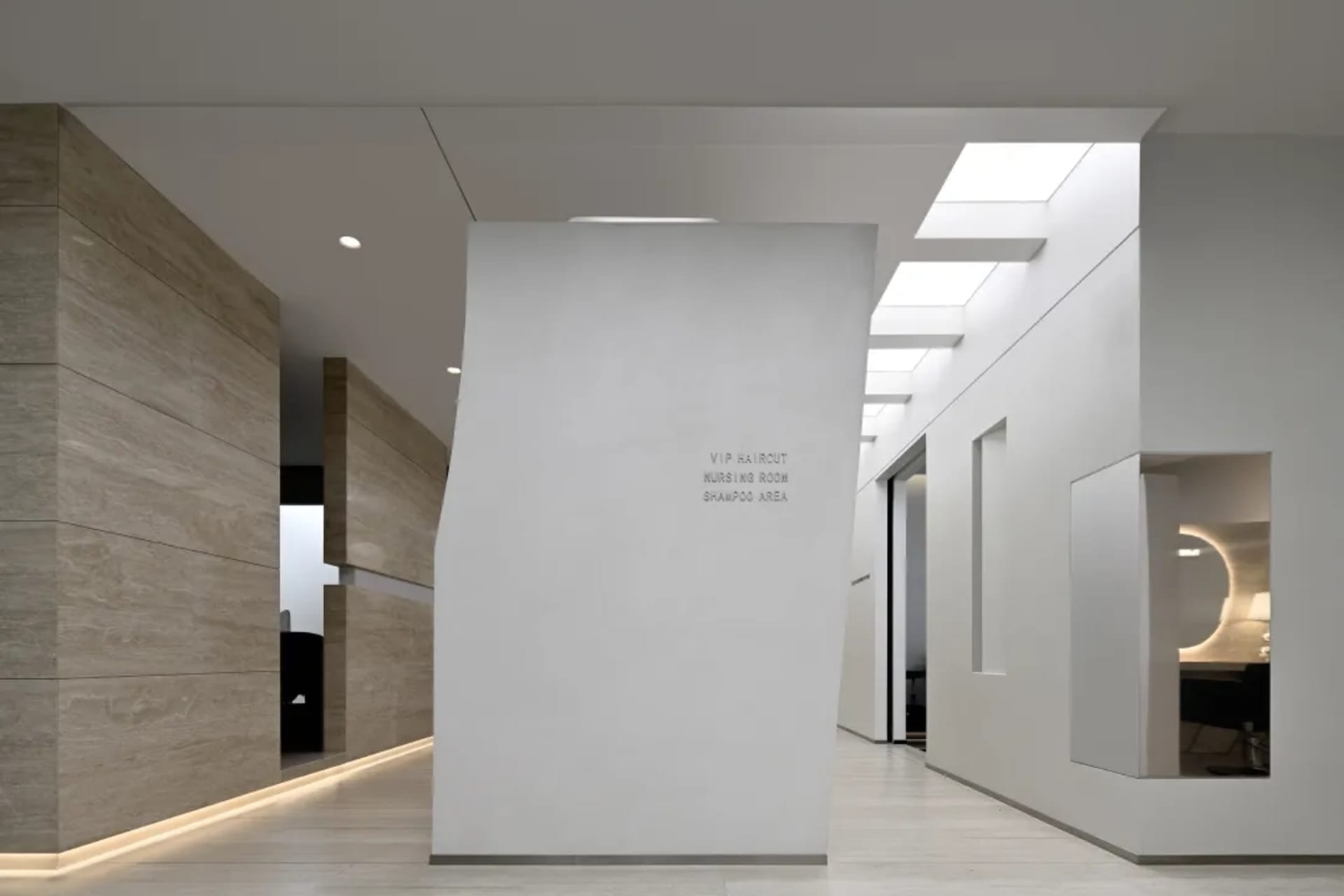An interior shot of a modern nursing room with white concrete walls and a white column.