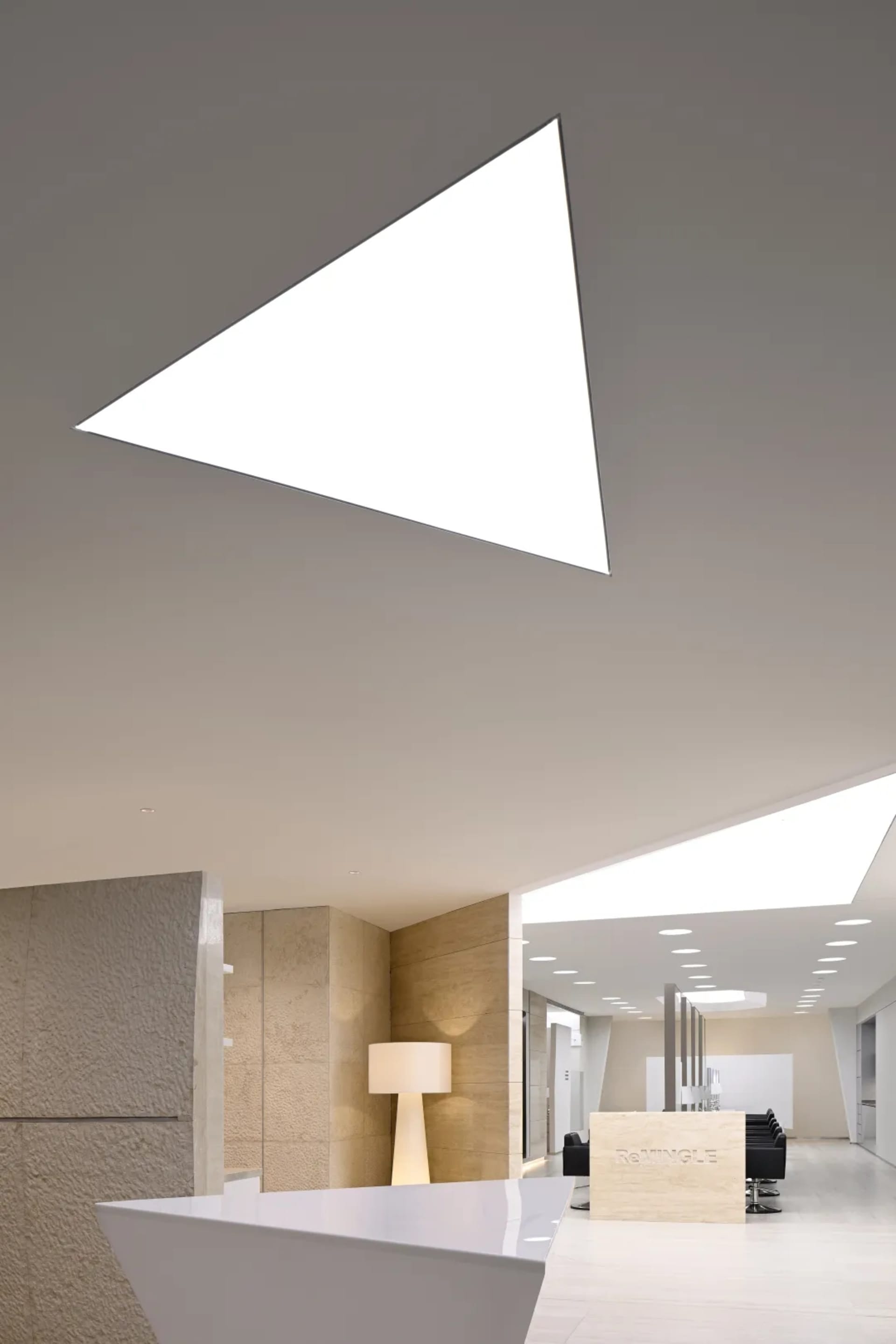 Modern office space with a large transparent window and minimalist design.