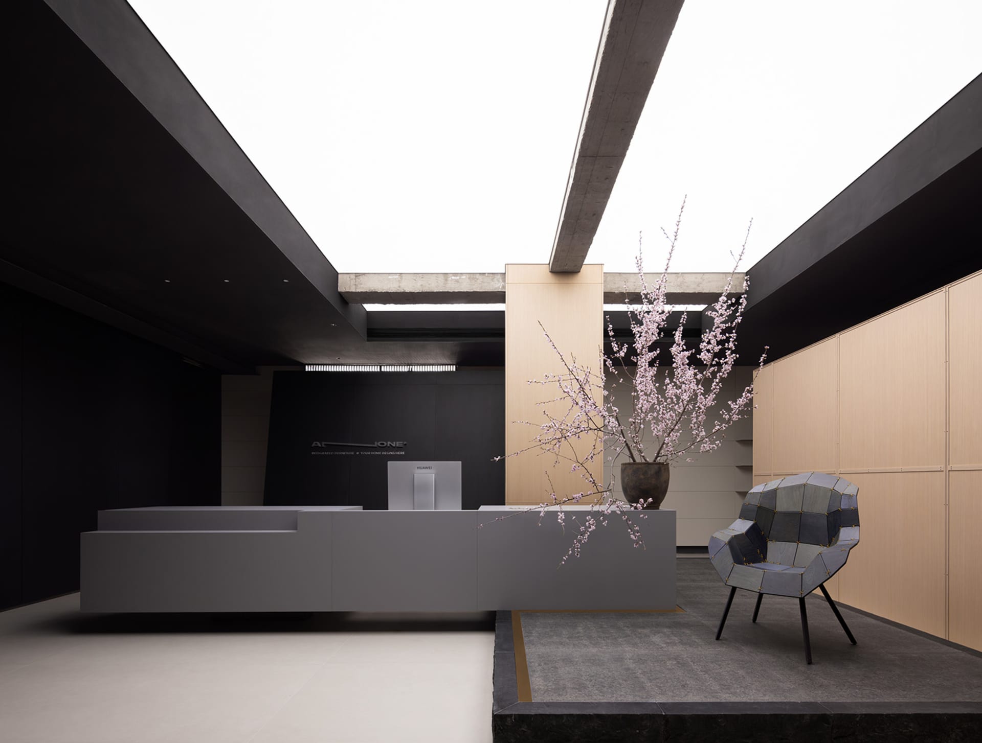 A modern office space with a white concrete floor, minimalist furniture, and a sleek desk.