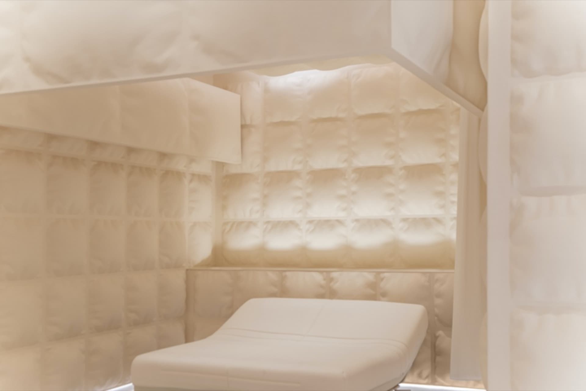 A minimalist room with textured cloth walls and a white cushioned bench.