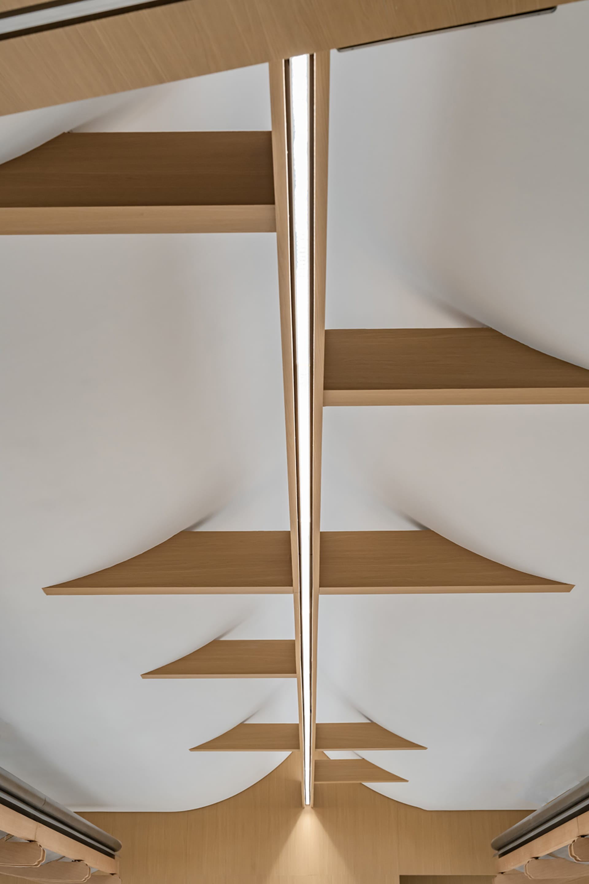 A modern interior space features light-colored wooden shelves mounted on a white ceiling with sleek, minimalist design.