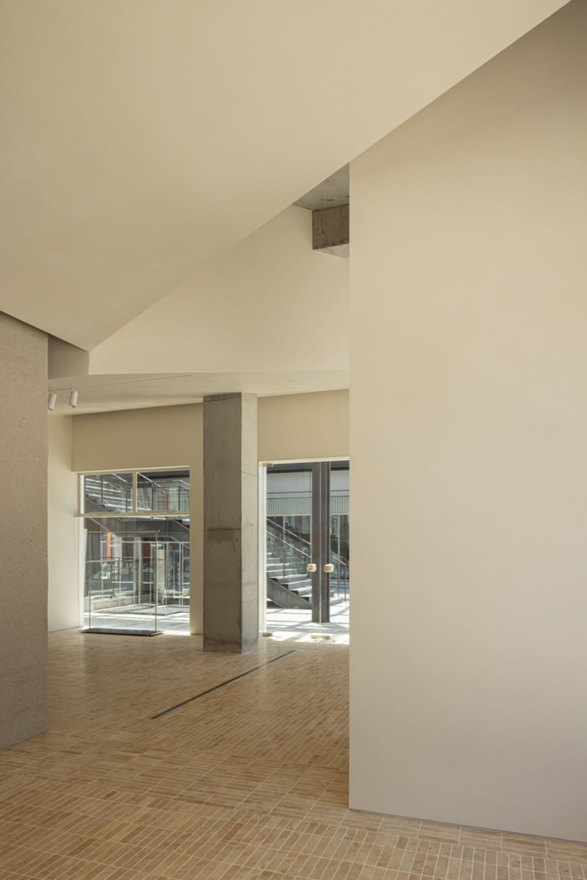 A minimalist interior design with beige walls and concrete elements.