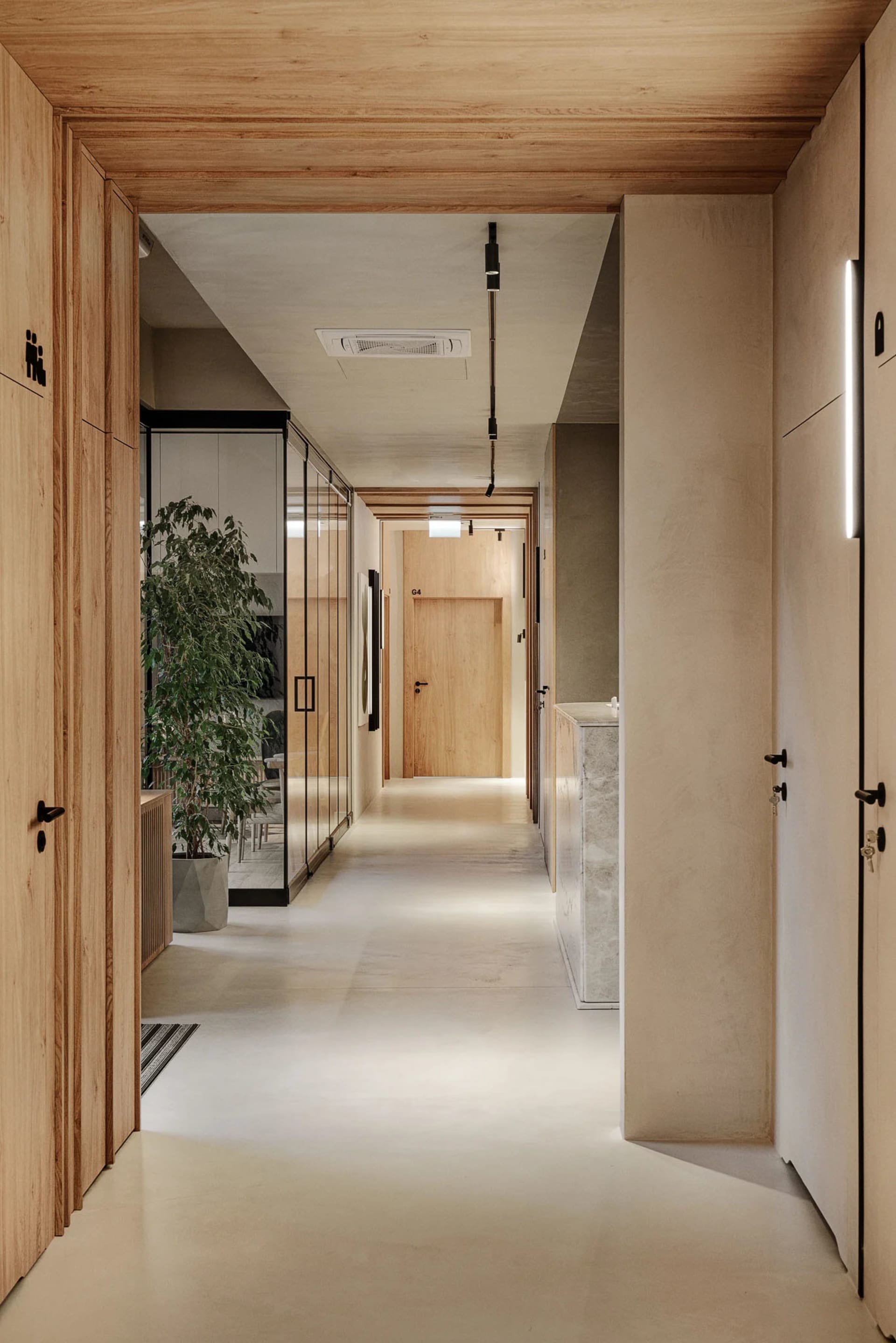 Modern interior design featuring a corridor with wooden walls and concrete flooring.