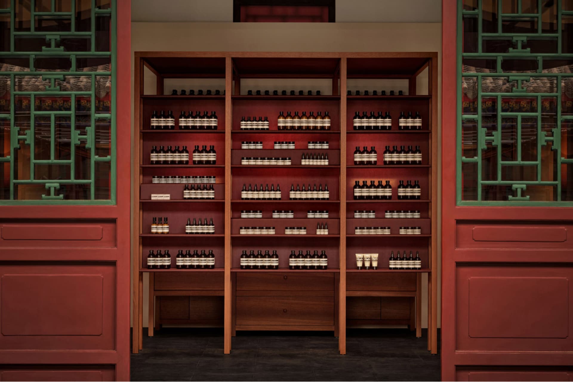 Well-lit retail store interior featuring modern wooden shelves stocked with bottles of products and glass display cases.