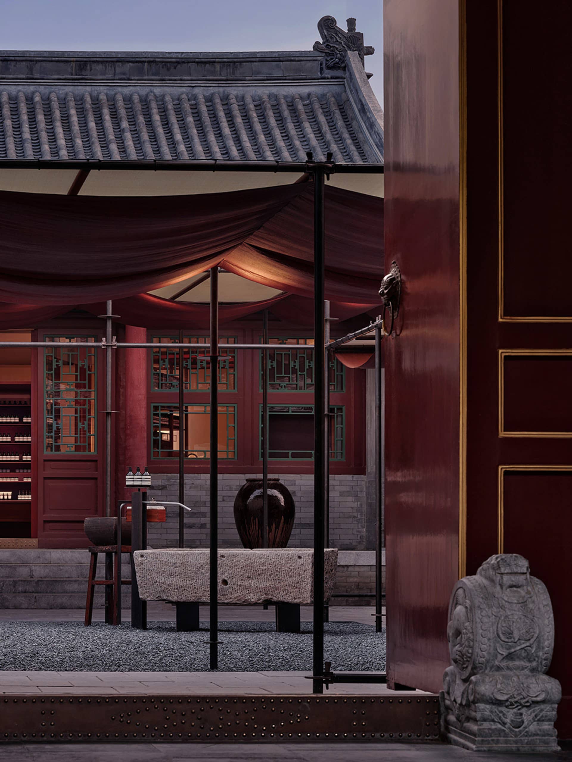 傳統寺廟內部視角，紅漆木構、石雕與陶土元素。