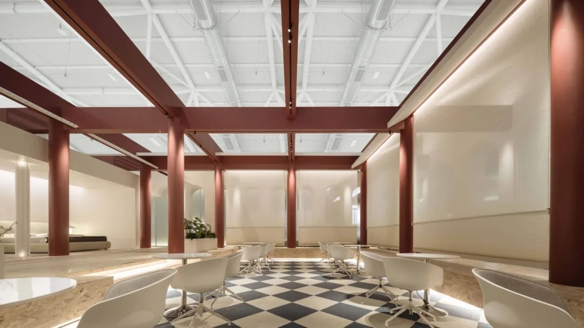 Modern interior design of a coffee shop with white concrete walls and checkered floor.