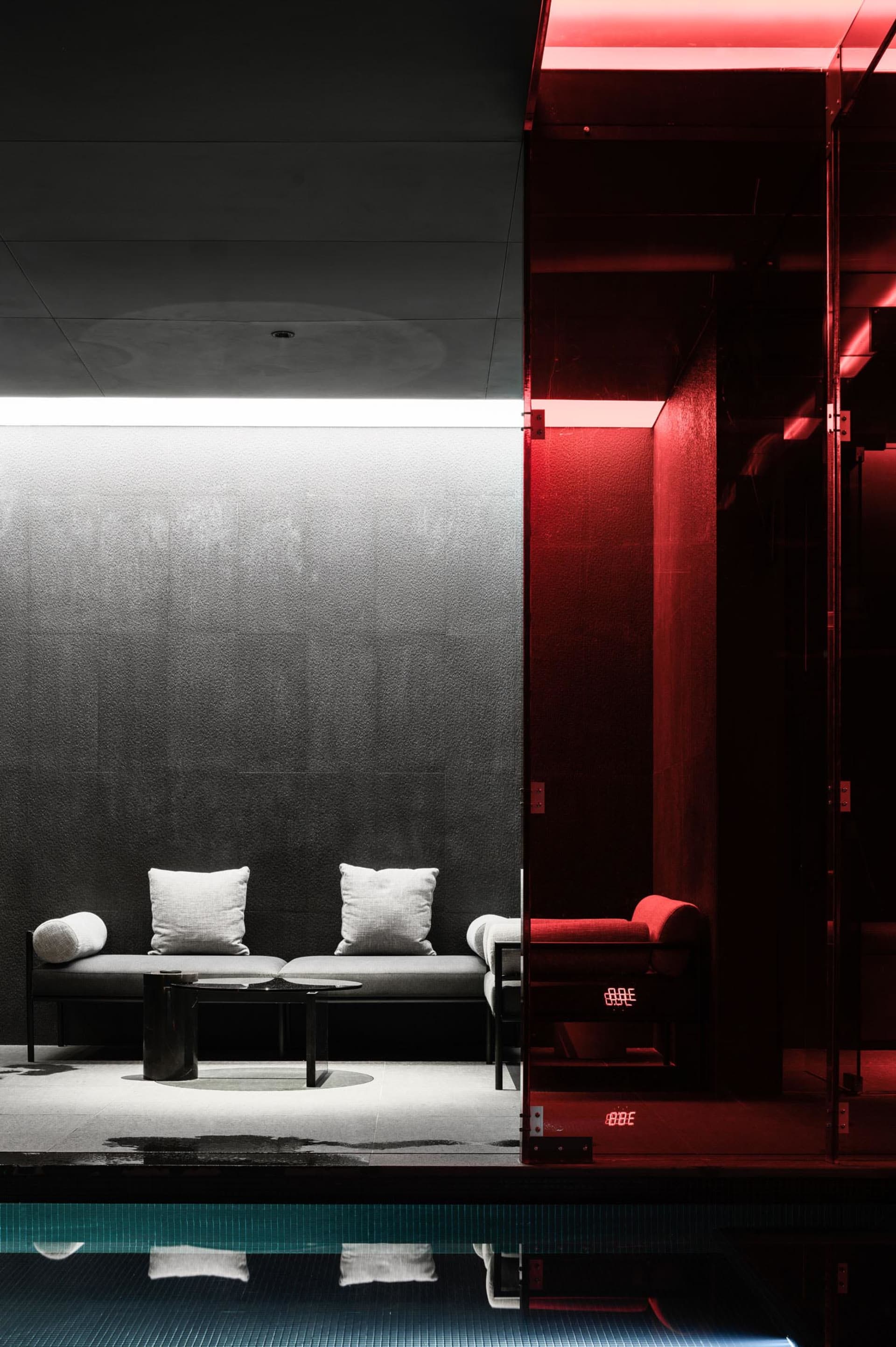 Modern, minimalist spa relaxation room featuring concrete and metal elements.