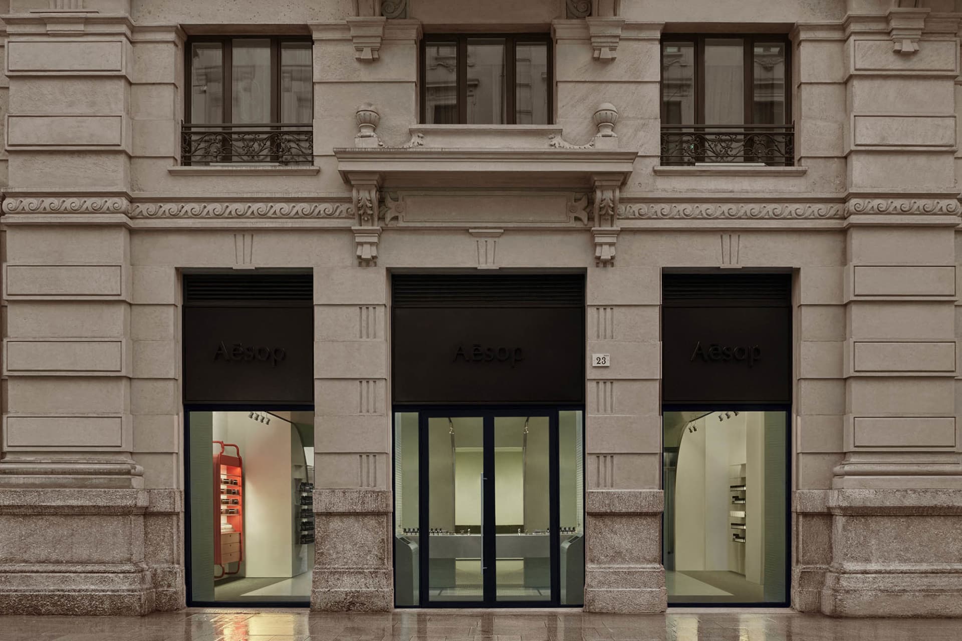 Modern storefront with stone facade and glass doors.