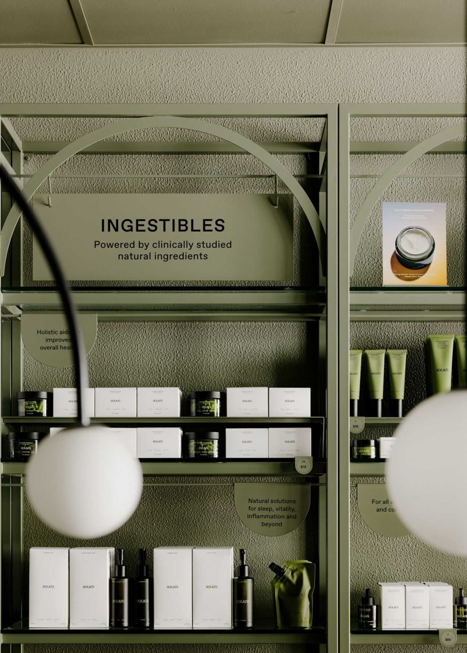 Modern retail interior showcasing cosmetic products on metal shelves with green glass containers.