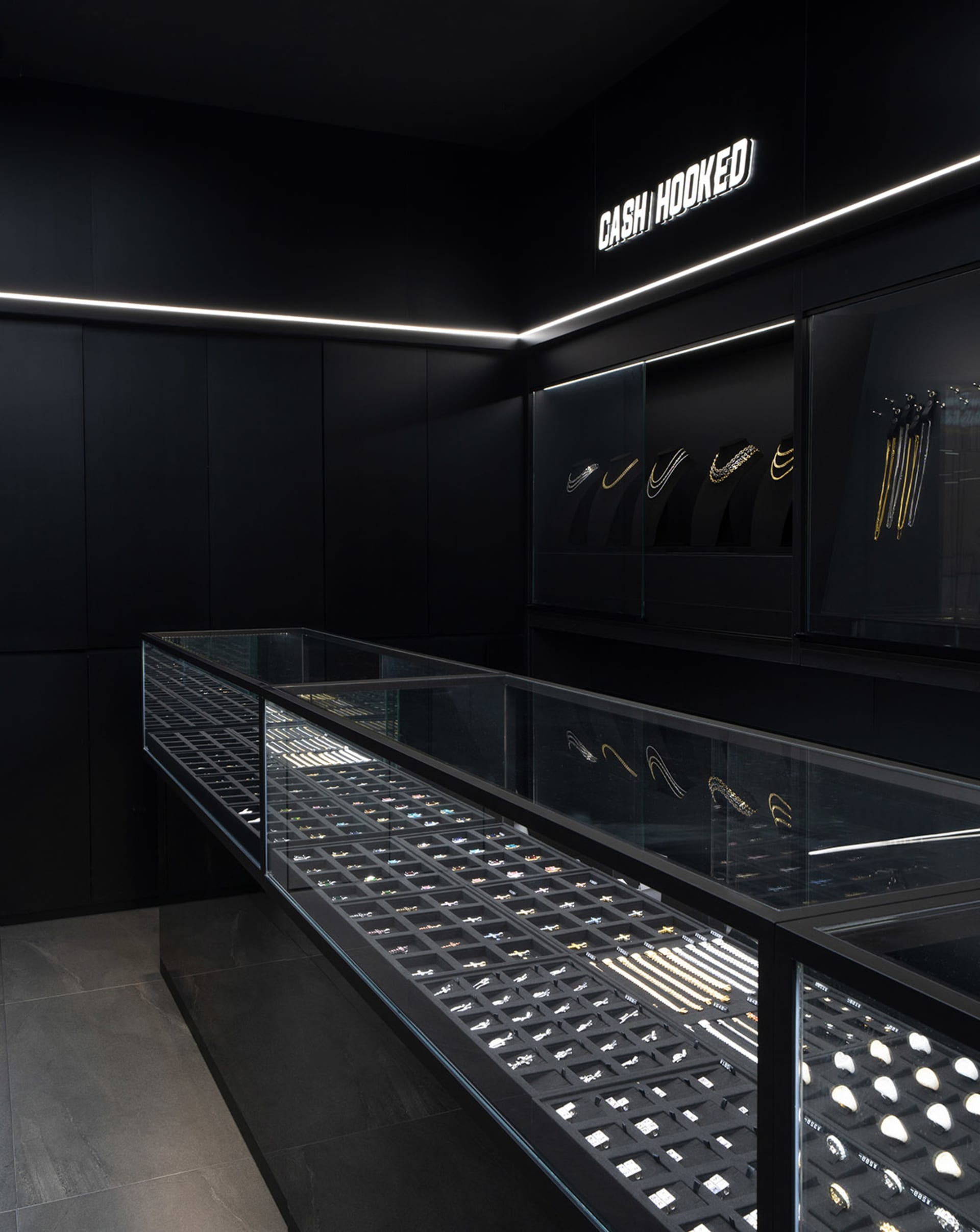 A contemporary jewelry display in a modern retail store showcasing elegant glass and metal fixtures.