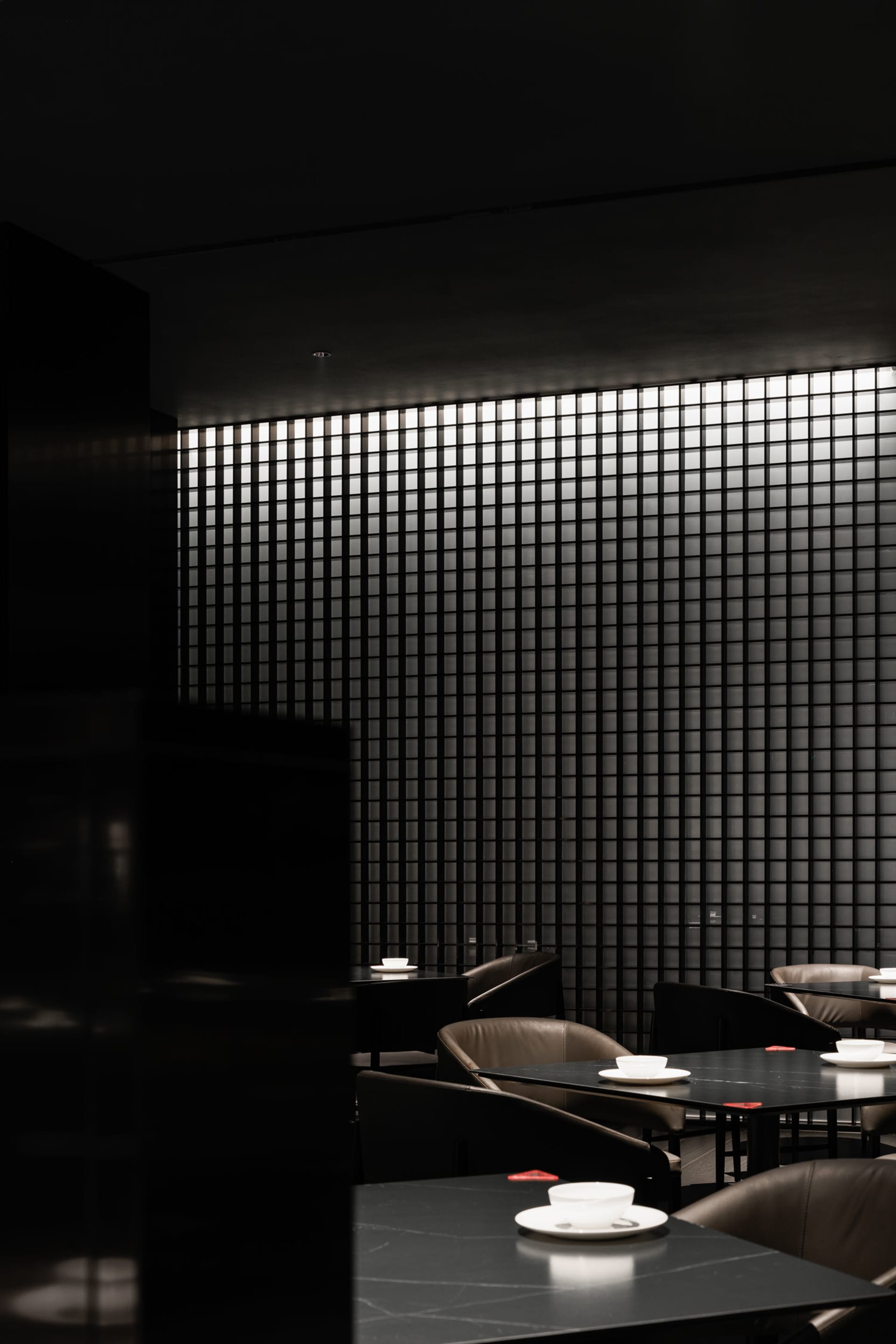 Minimalist restaurant interior with black and glass design elements.