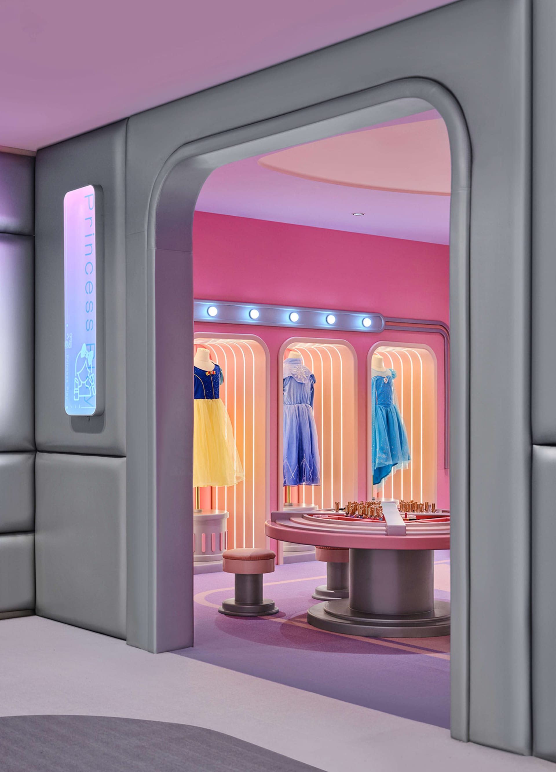 Modern retail space featuring colorful dresses on mannequins.