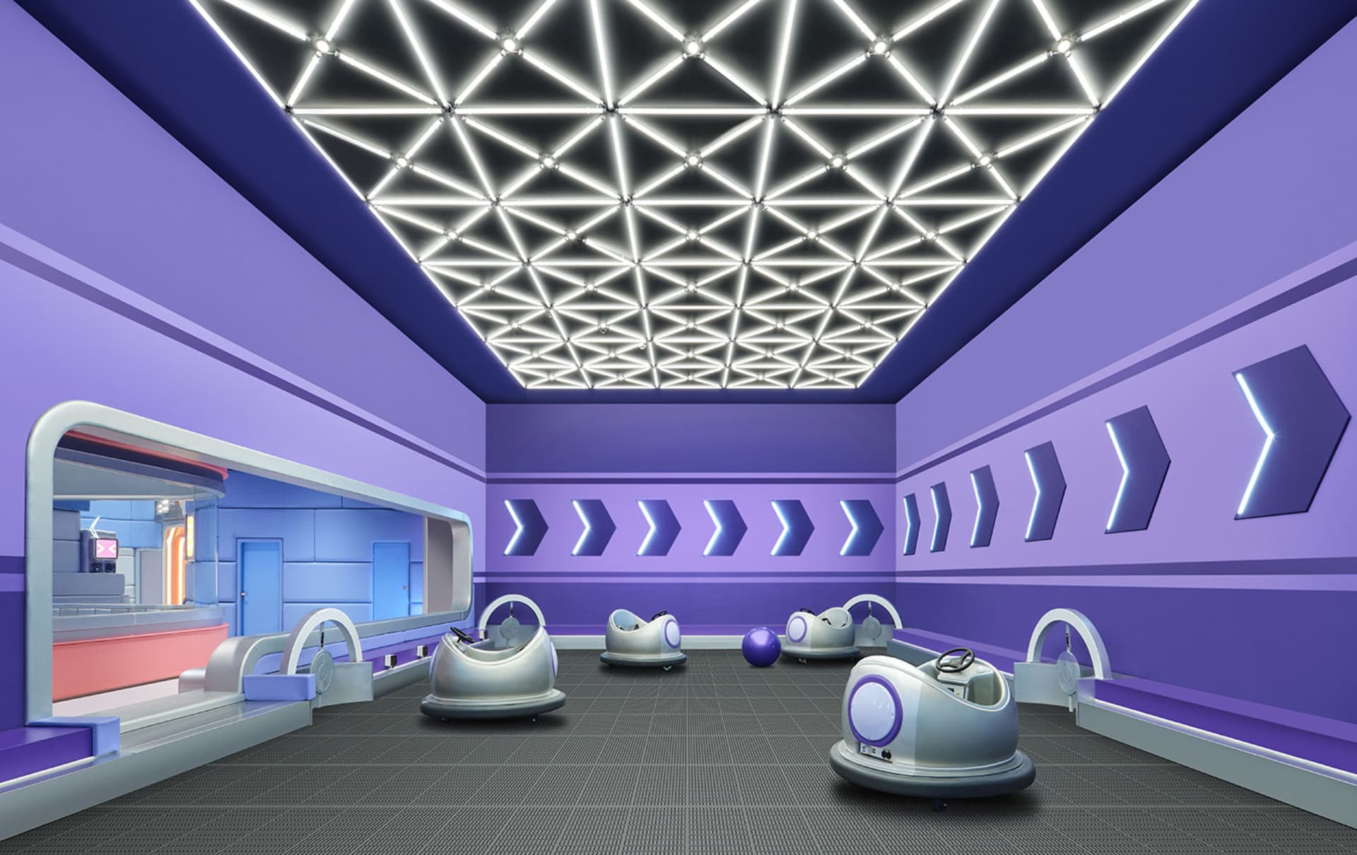 An industrial-style gymnasium with metallic bumper cars and futuristic lighting.