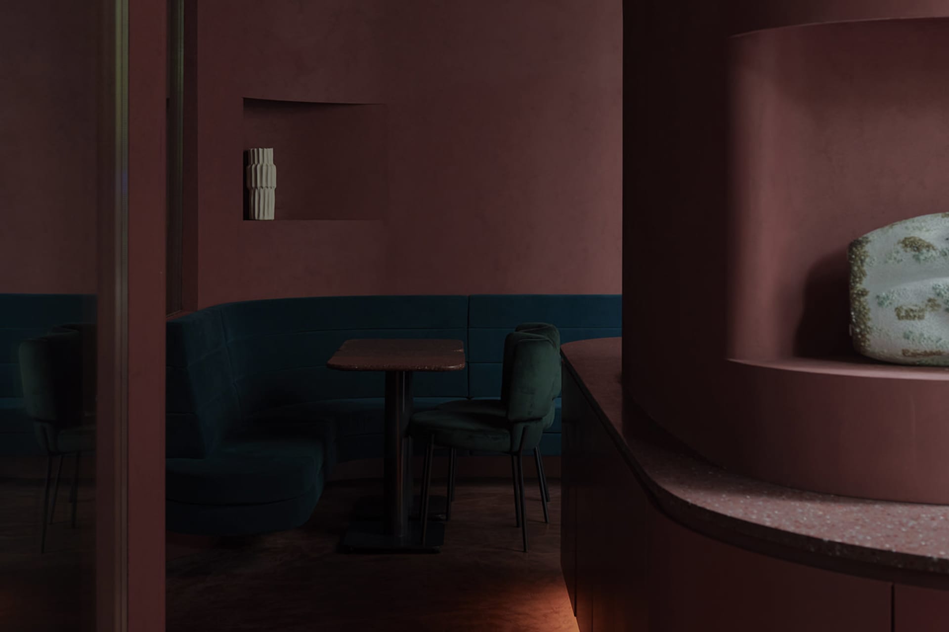 Contemporary restaurant with dark blue velvet seating and marble table surface.