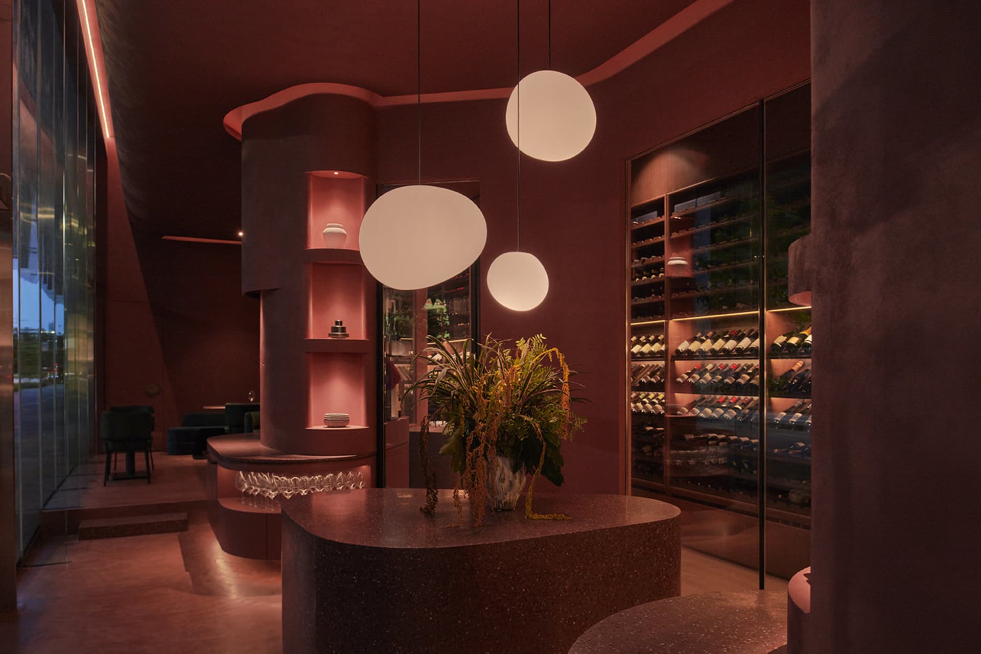 Modern interior design of a wine bar featuring concrete walls, terrazzo flooring, and natural light from large windows.