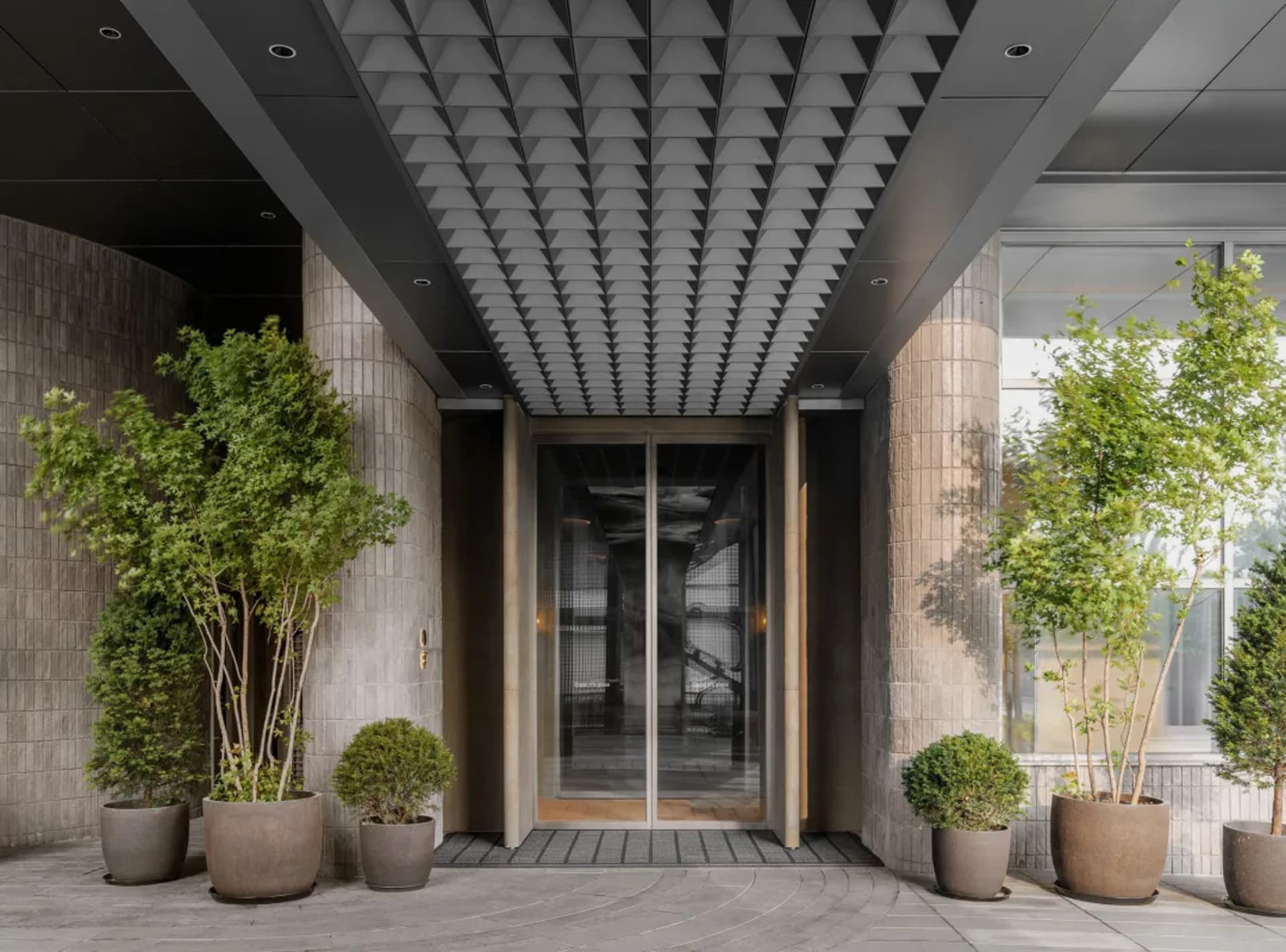 A modern entrance with concrete walls and a glass door.