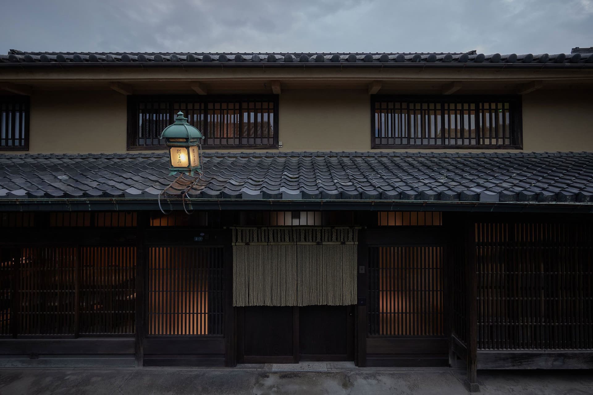 傳統日式建築搭配灰色瓦片屋頂與木製百葉窗。