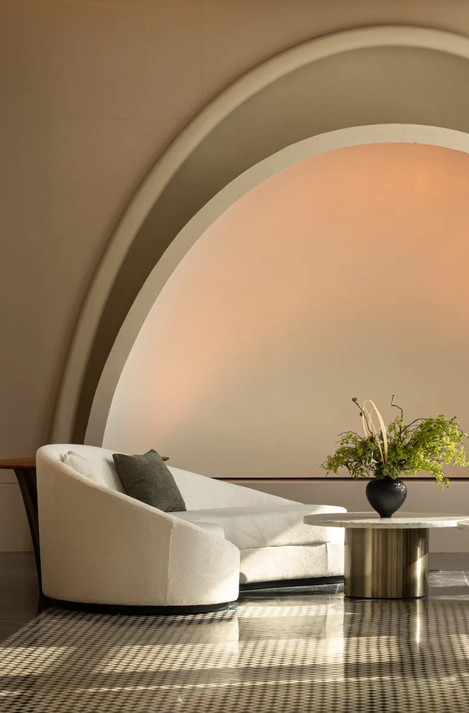 Modern minimalist living room interior with neutral color palette and arch-shaped ceiling feature.