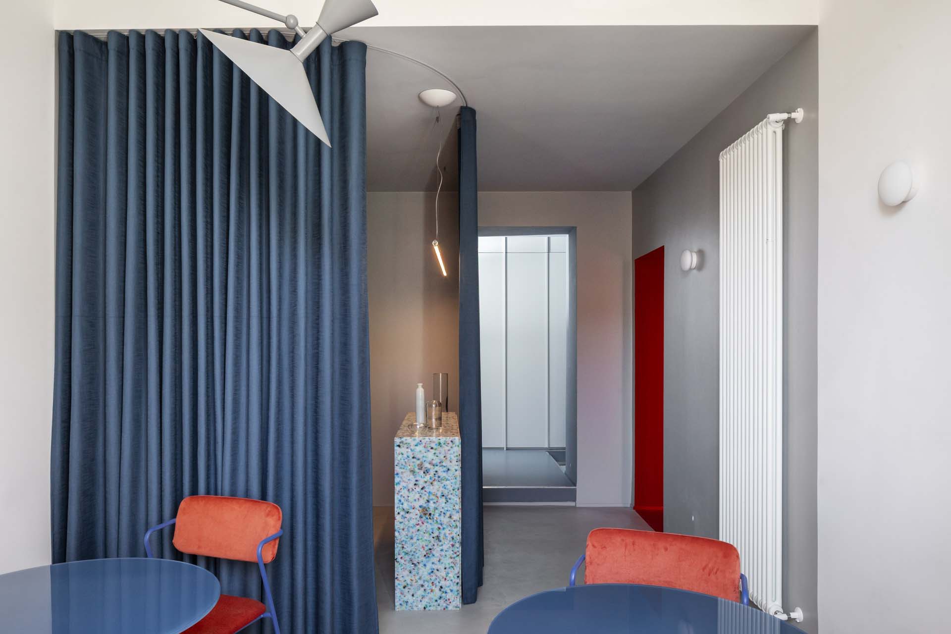 Modern dining room featuring blue fabric seating and a blue table.