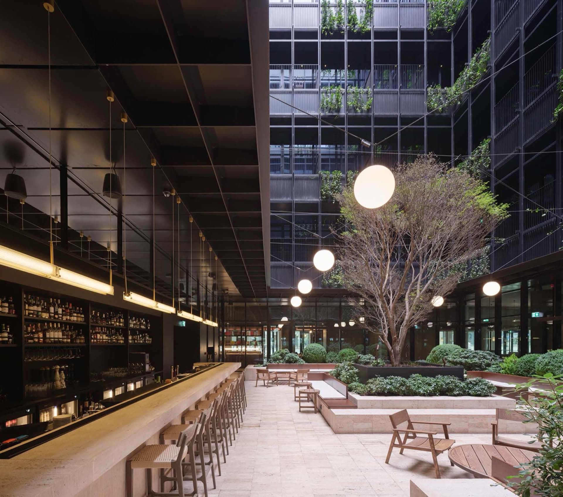 A modern corporate office with glass walls, concrete floors, and wooden furniture.