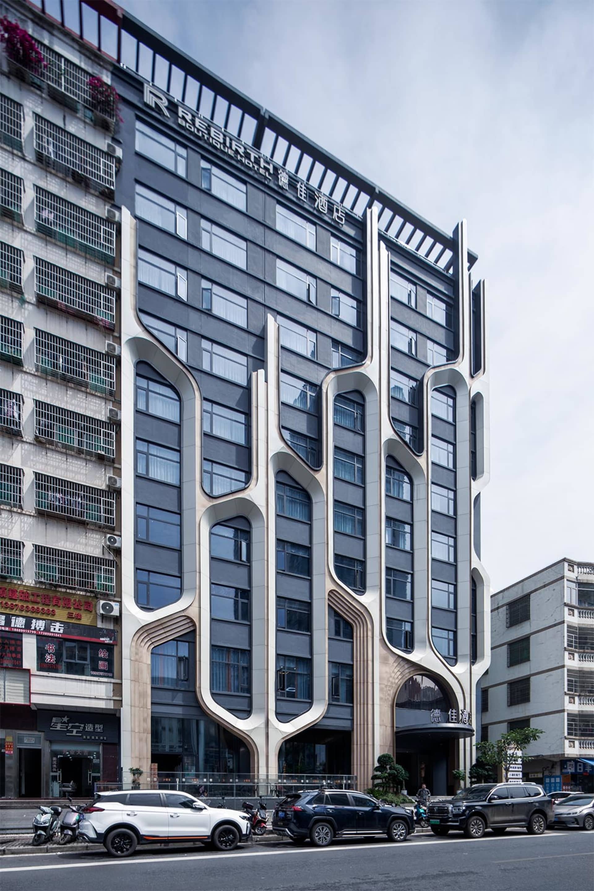 Modern building exterior featuring concrete and glass materials in an urban setting.