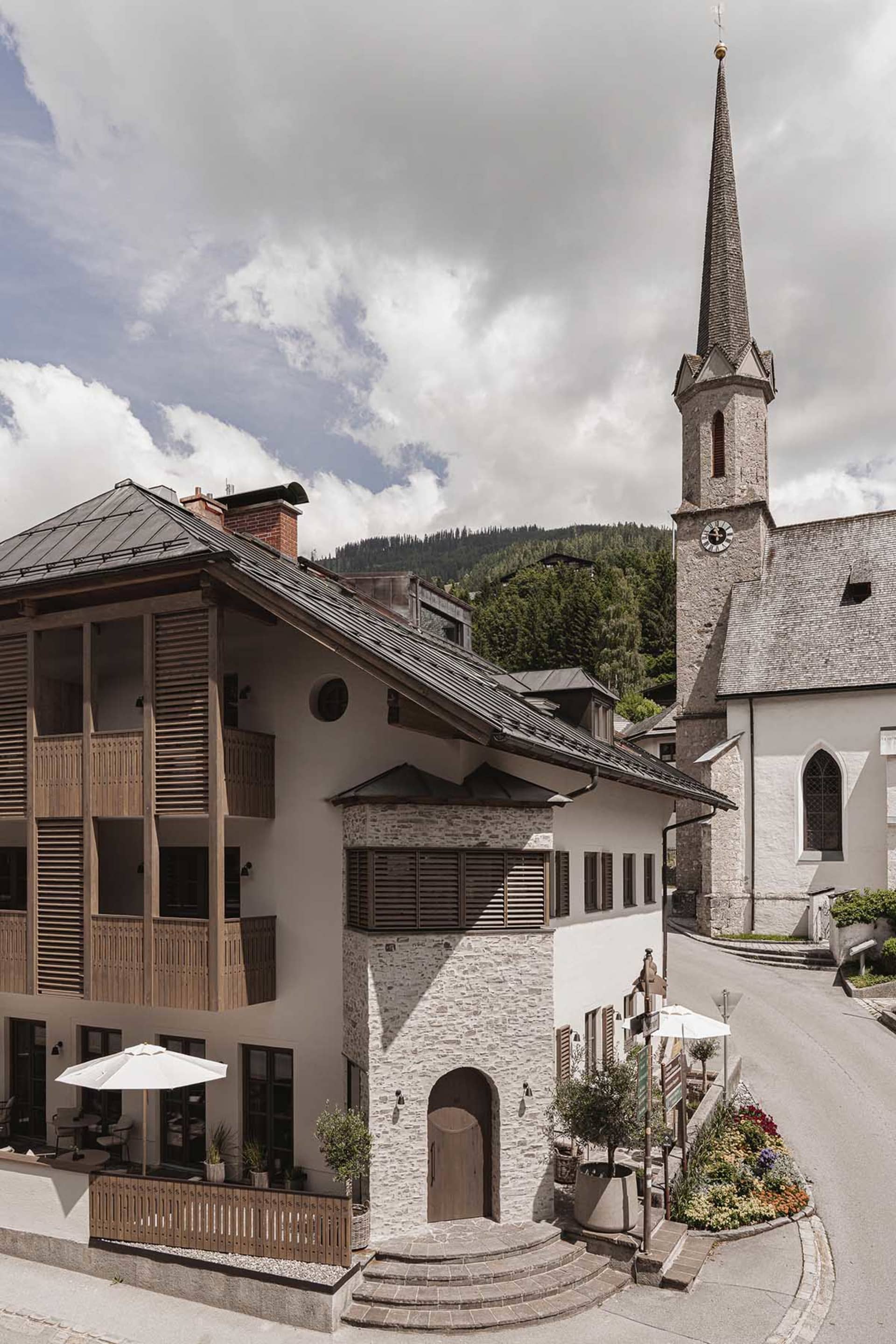 A picturesque village center featuring stone buildings, wooden balconies, and metallic accents.