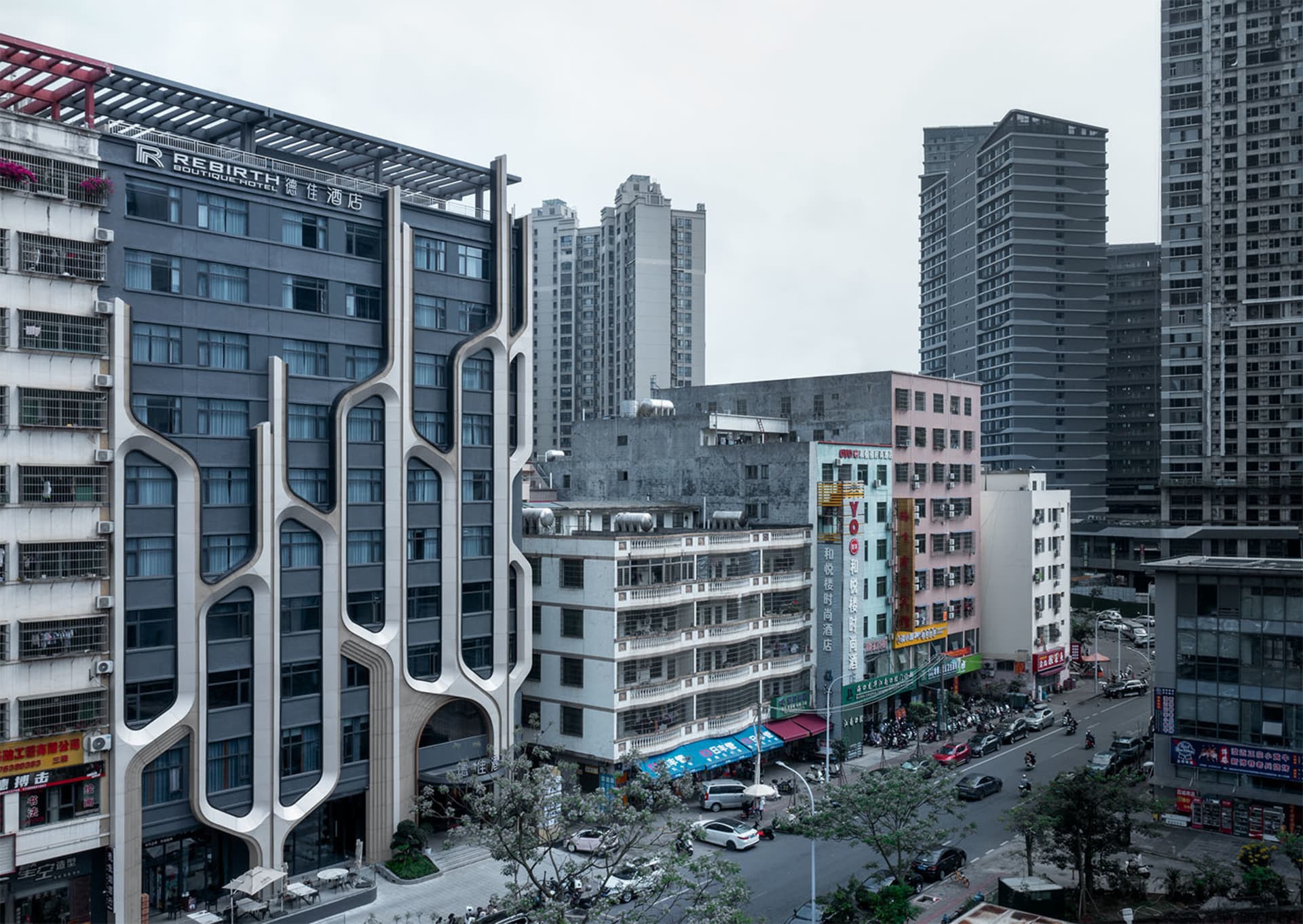 A modern urban streetscape featuring a variety of buildings with unique architectural designs and a bustling street filled wi