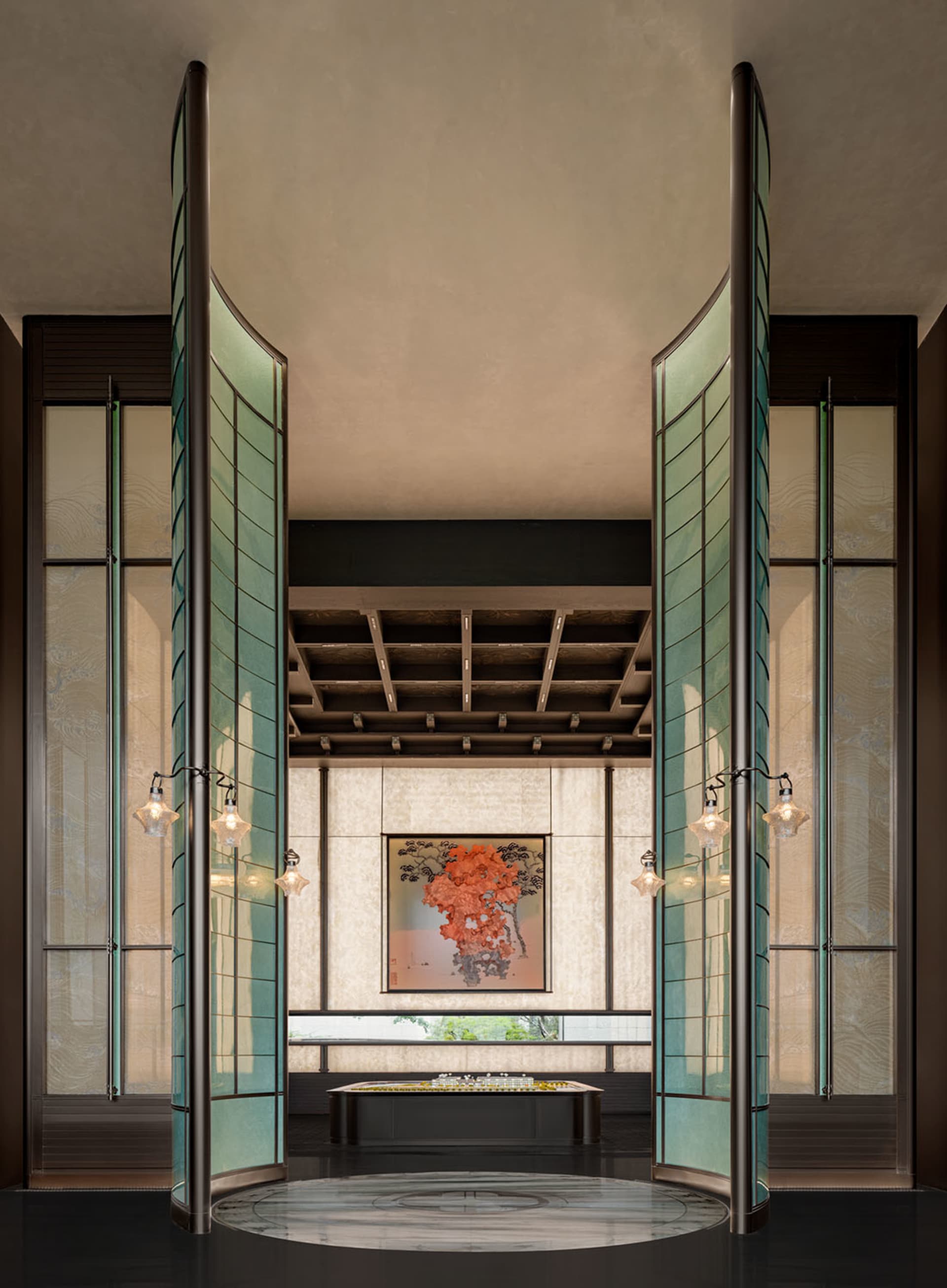 A modern lobby with large glass doors and a painting on the wall.