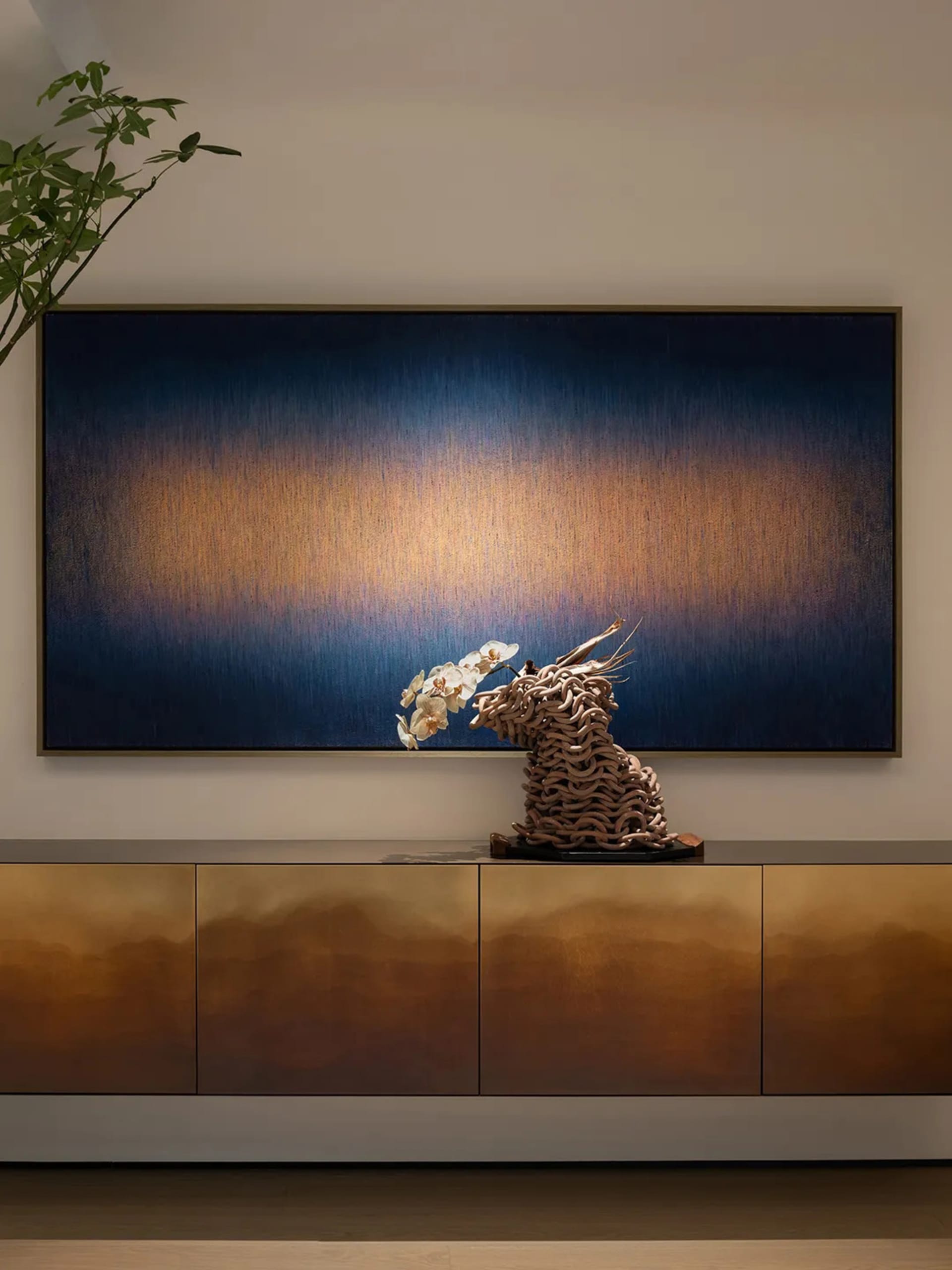Modern living room featuring a metallic console with a cloud-like abstract sculpture on top and a large abstract painting on