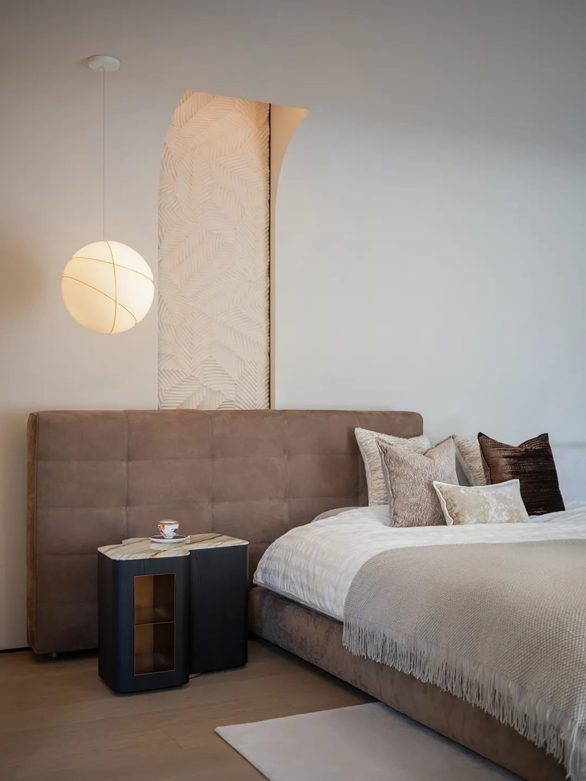 Modern minimalist bedroom featuring plush velvet bedding, marble nightstand, and wooden accents, showcasing sophisticated des