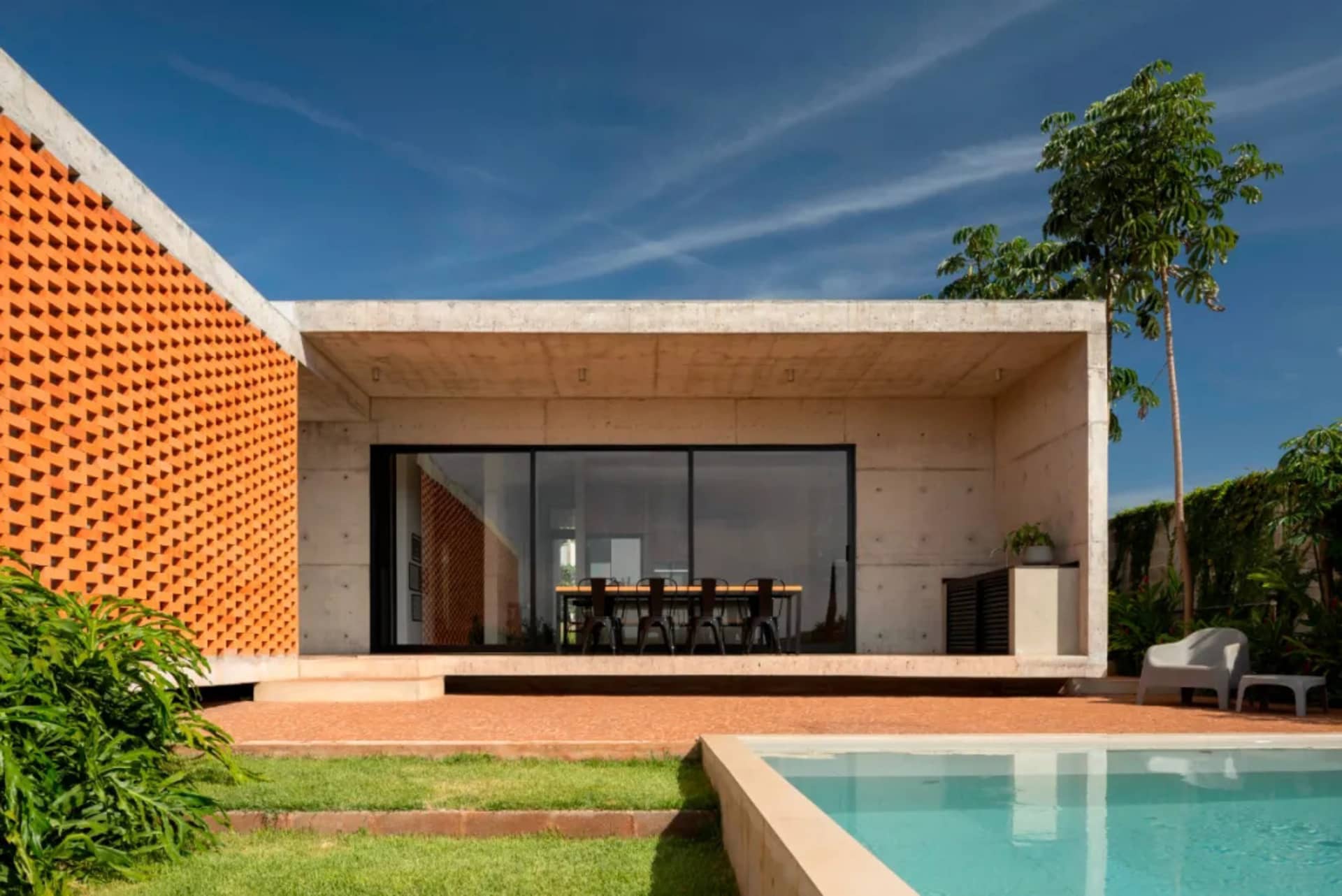 Modern building exterior with a concrete facade and a covered patio area.