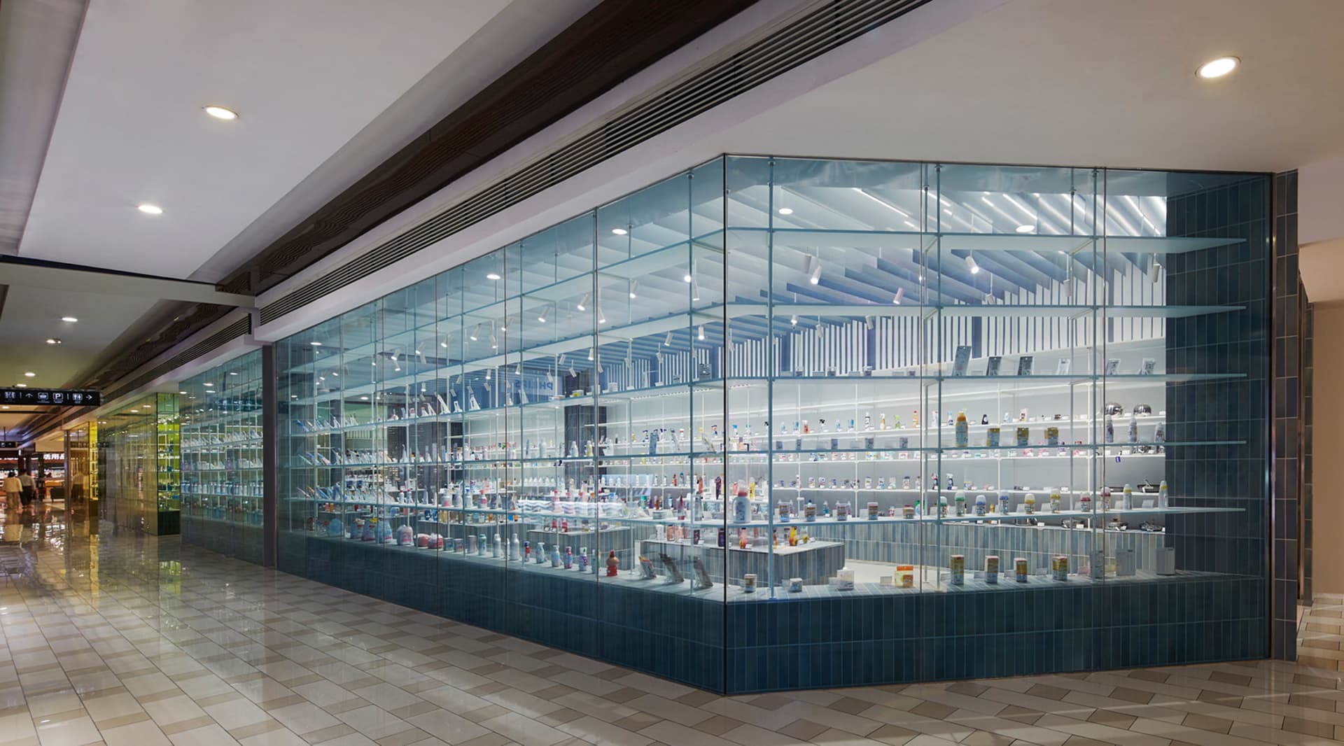 A glass storefront displaying various products on shelves within a retail space.
