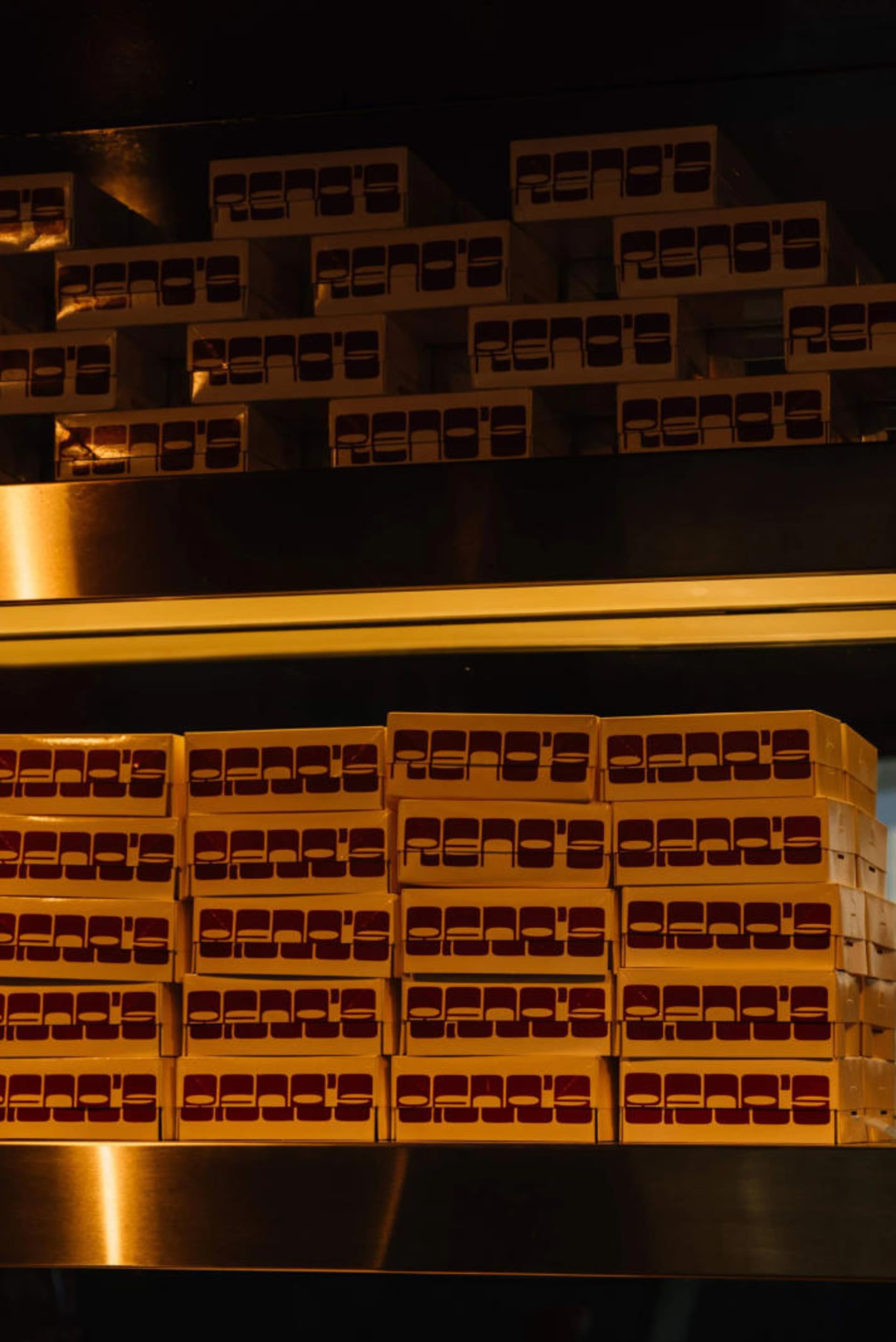 Stacked cardboard boxes with red text on a reflective surface.
