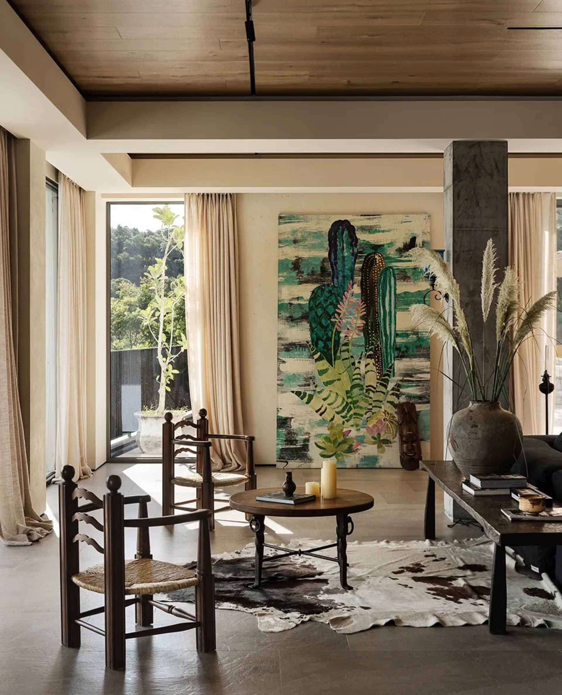 A modern living room with concrete and wood materials and a large abstract painting.