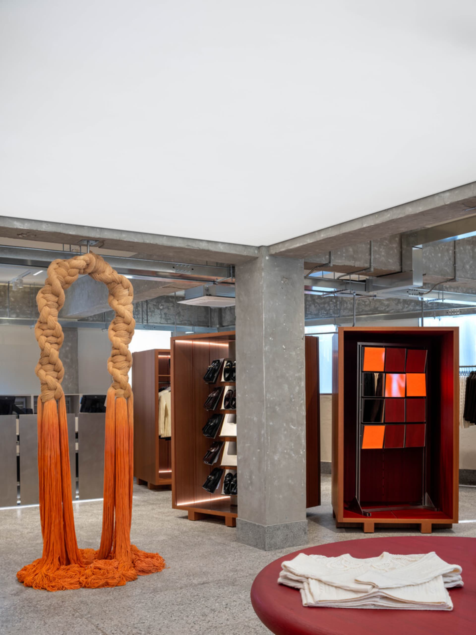 A modern retail store interior featuring wooden shelves, concrete walls, and glass display cases.