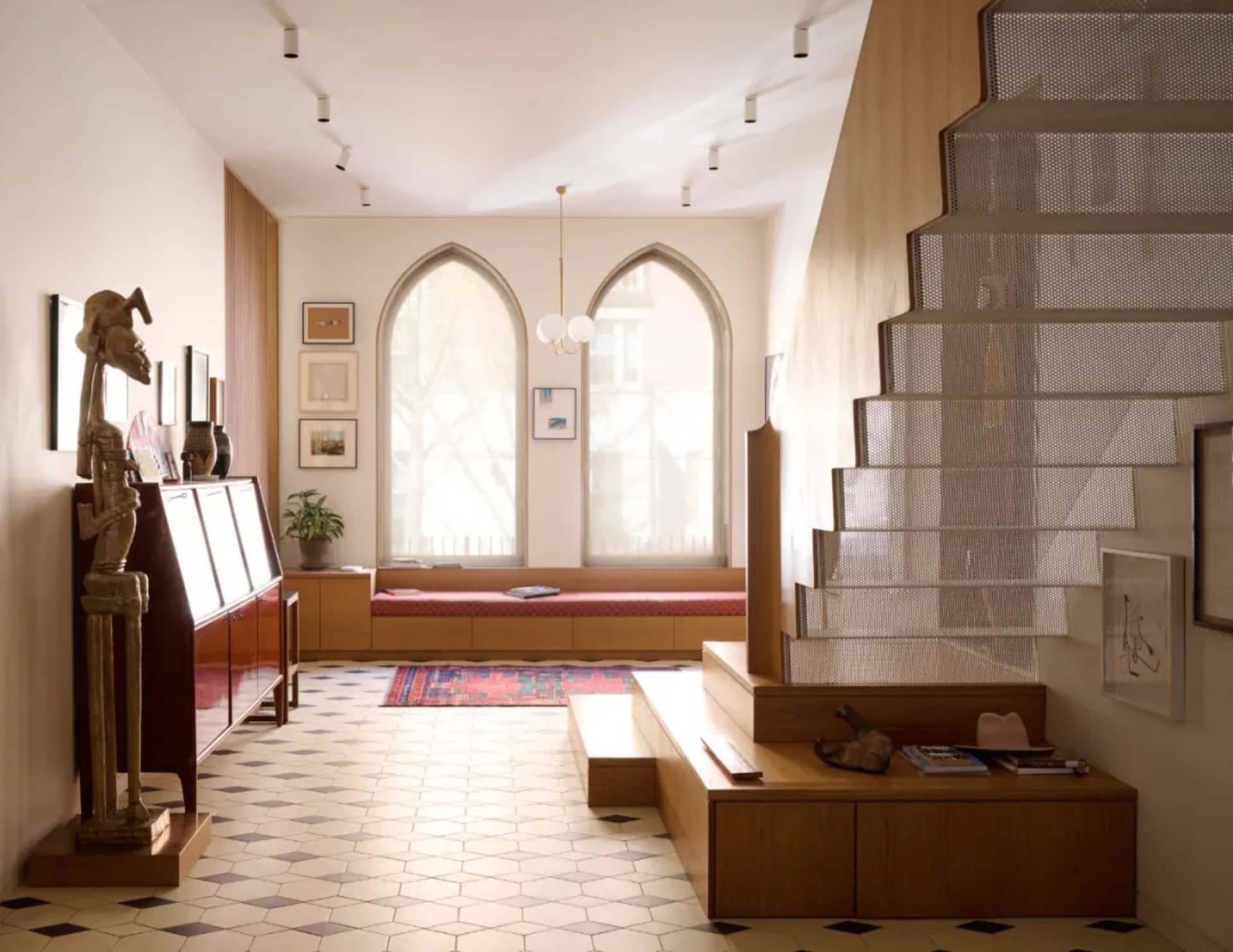 A modern living room featuring wooden and metallic elements, a textile-covered seating area, and a plaster staircase.
