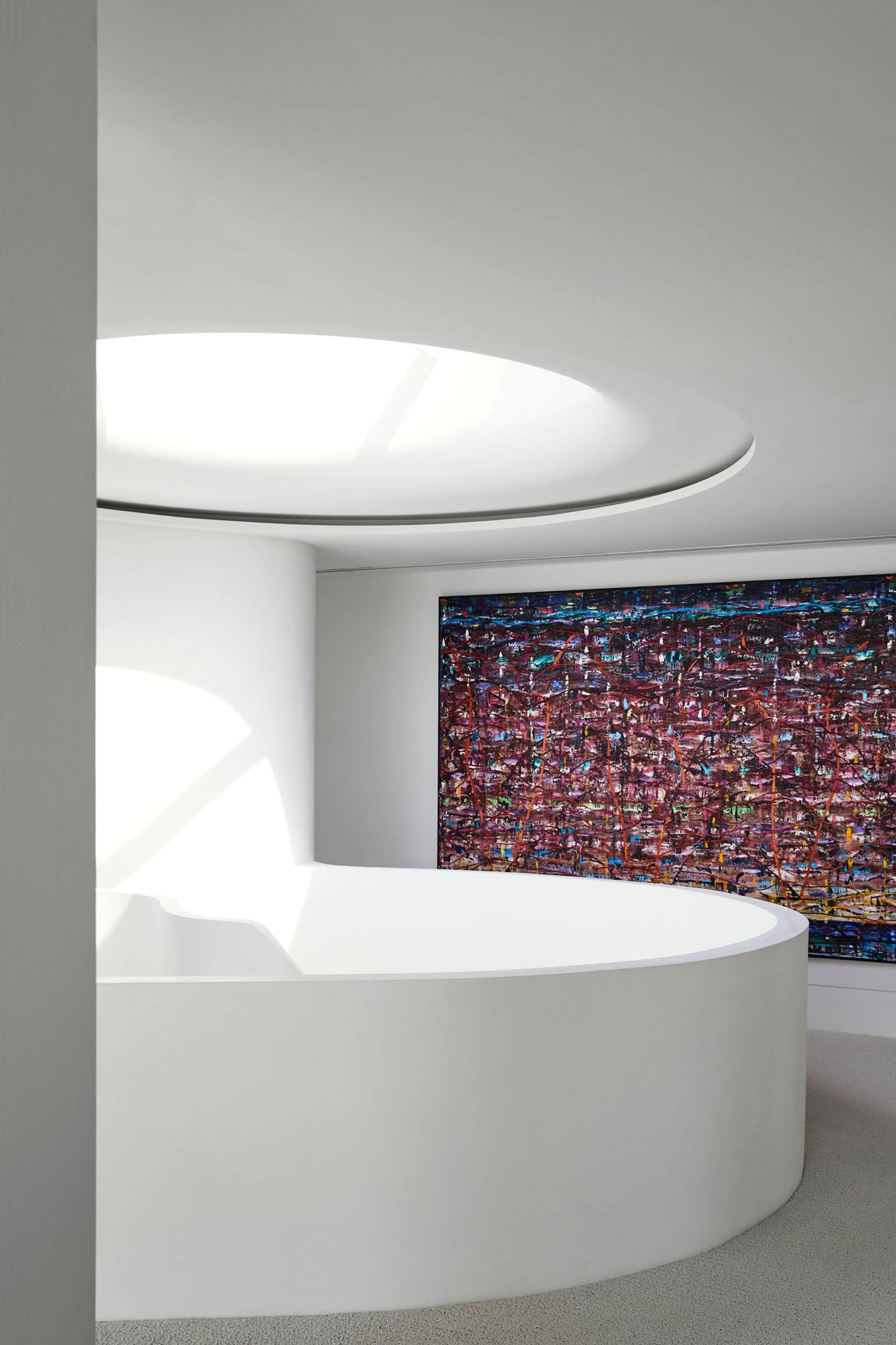 Modern interior design featuring sleek, white concrete walls and a large, abstract painting on the wall.