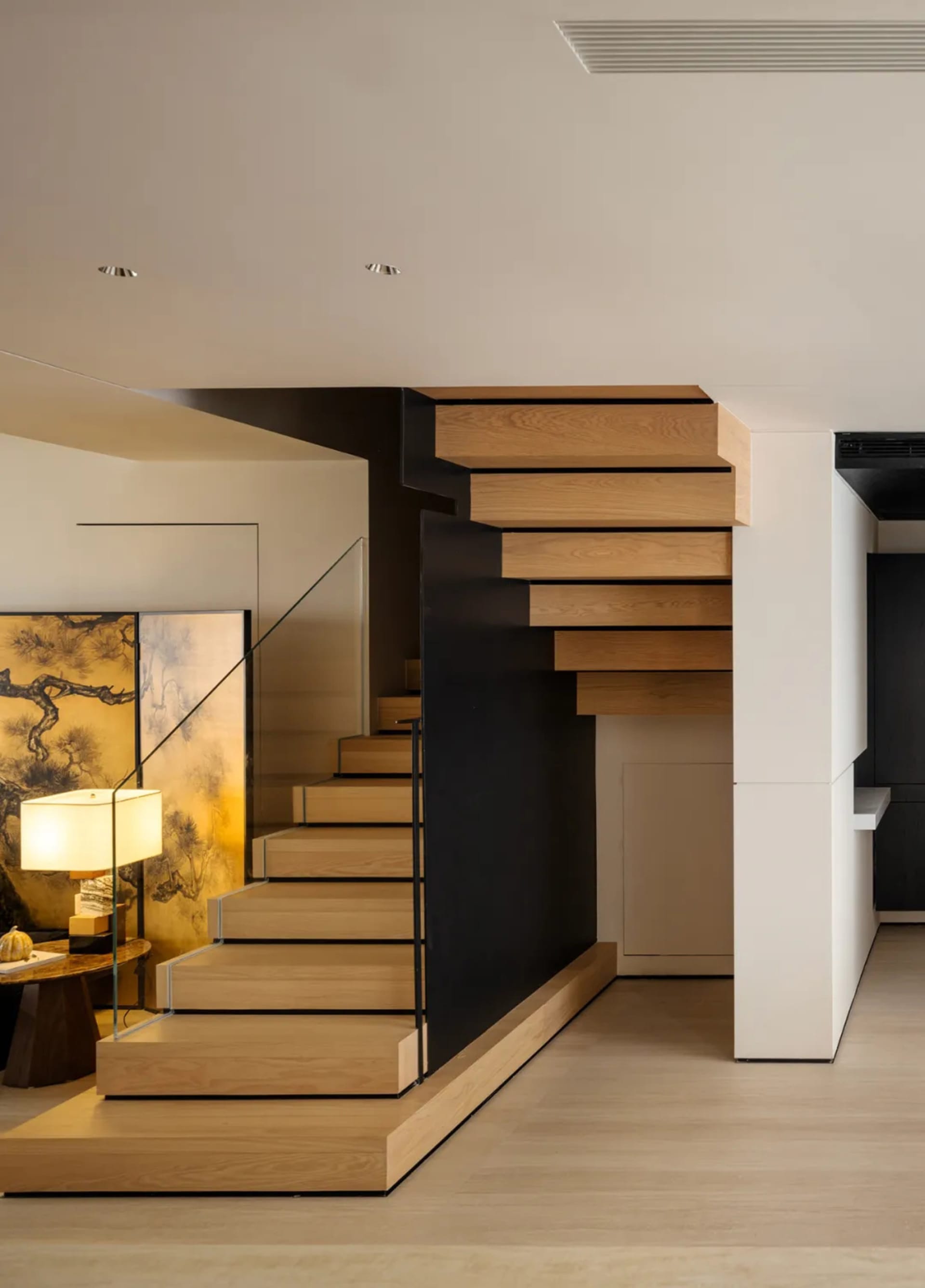 Modern interior design featuring a wooden staircase with floating steps and a sleek, minimalist aesthetic.