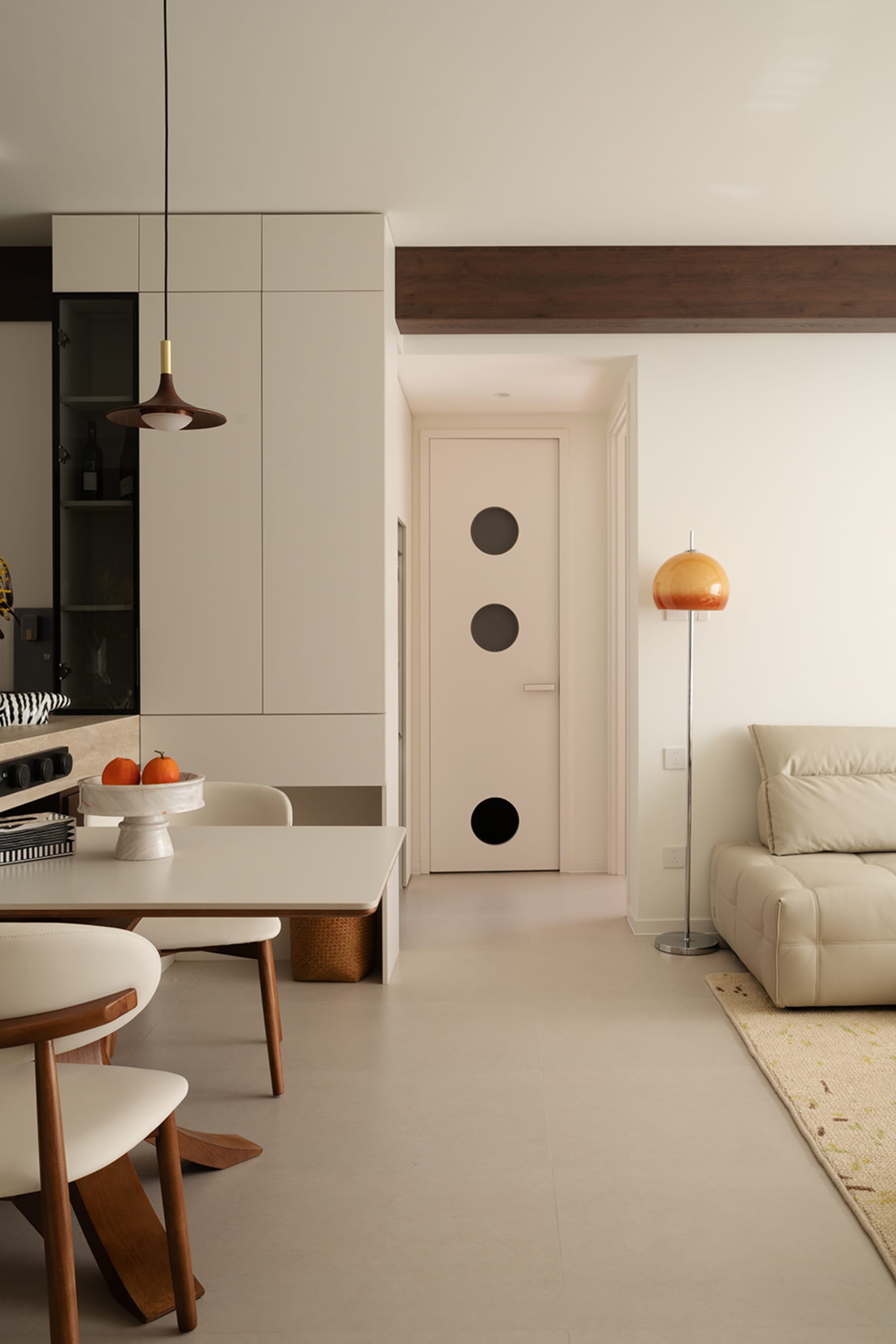 Modern minimalist living and dining room featuring concrete tiles and wood finishes.